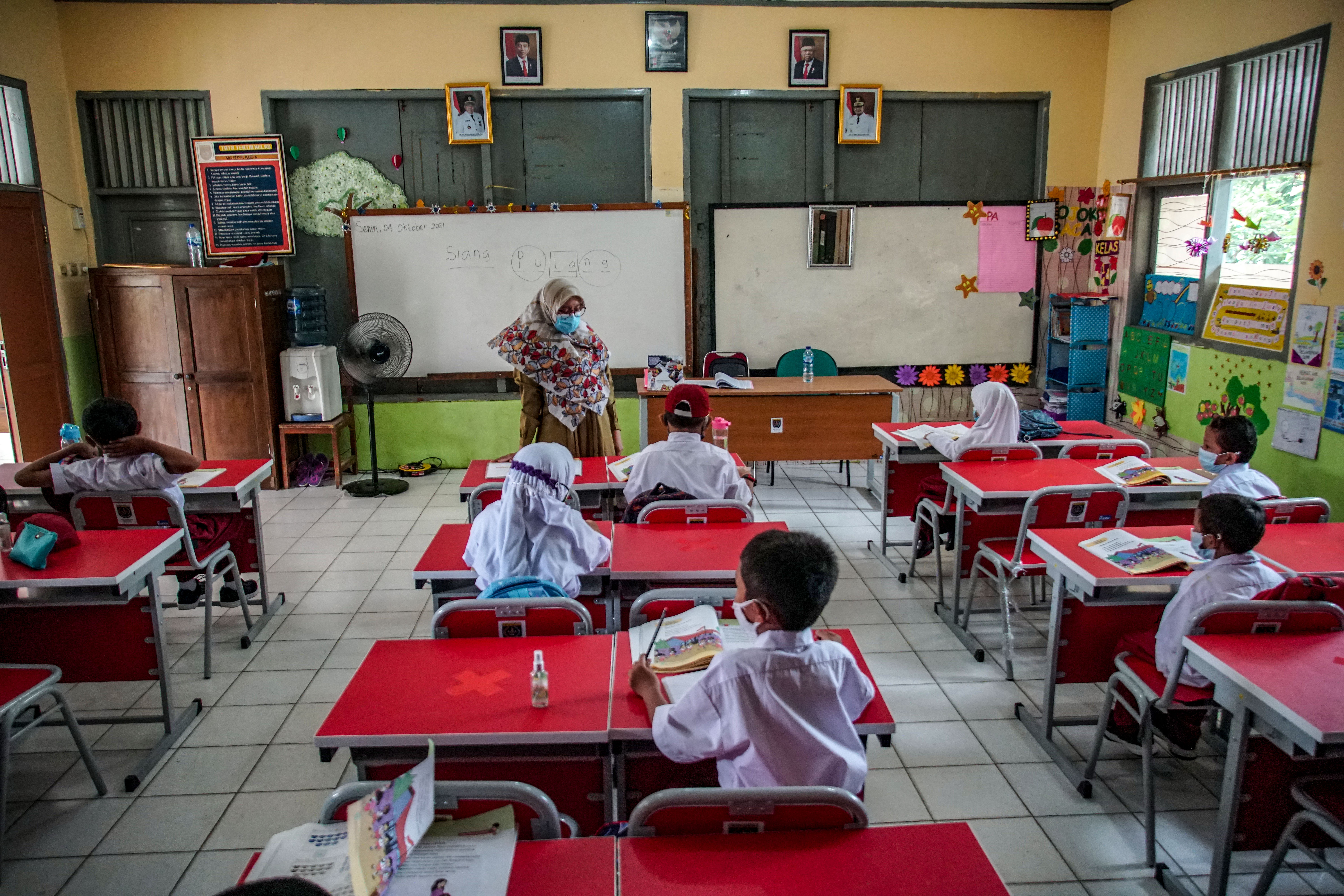 Sejumlah siswa menyimak pemaparan guru pada hari pertama PTM terbatas di SDN Depok Baru 8, Kota Depok, Jawa Barat, Senin (4/10/2021)