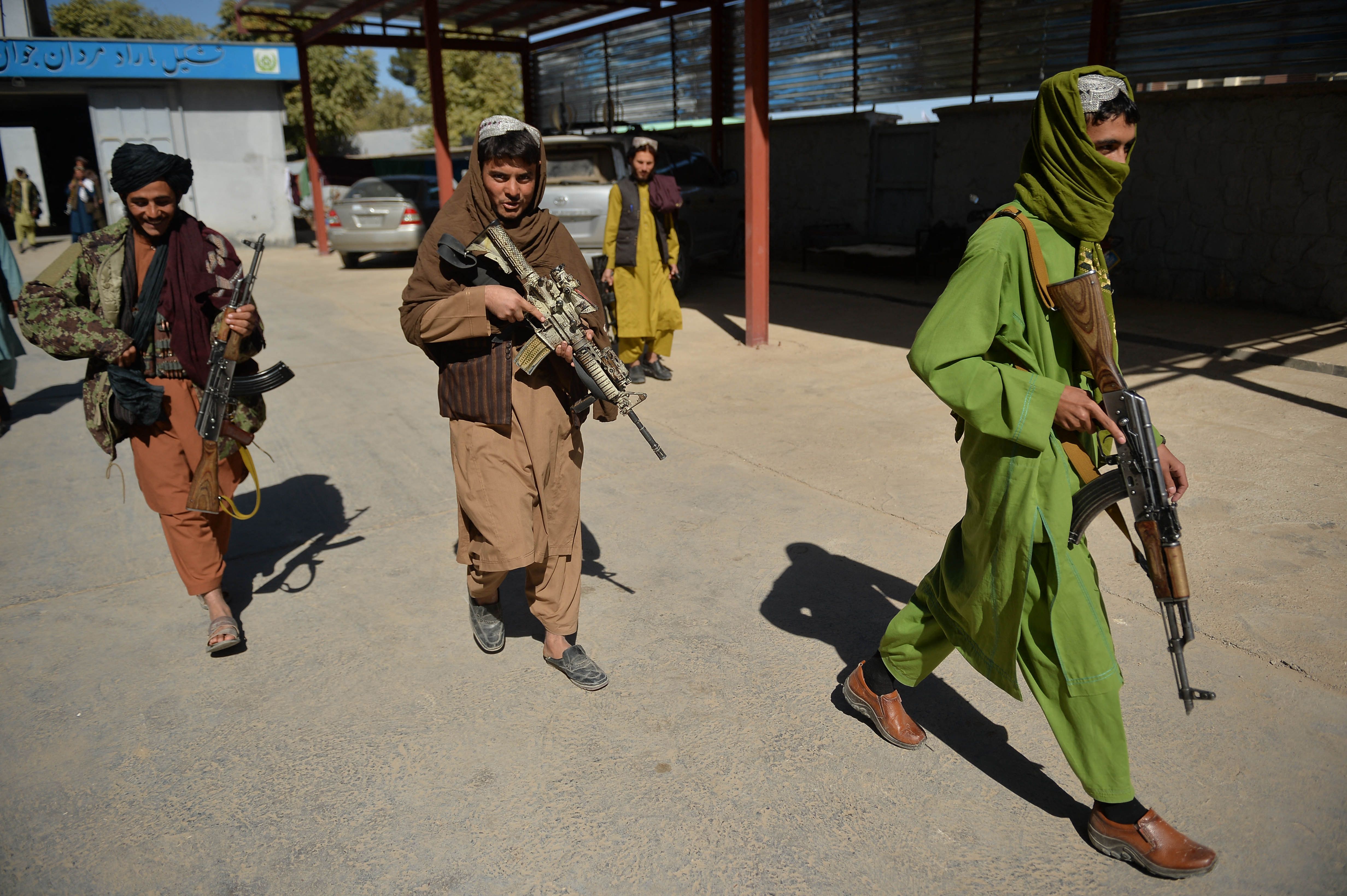 Sejumlah pasukan Taliban berjalan di sekitar markas kepolisian wilayah Qala-e-Now, Badghis, Afghanistan.