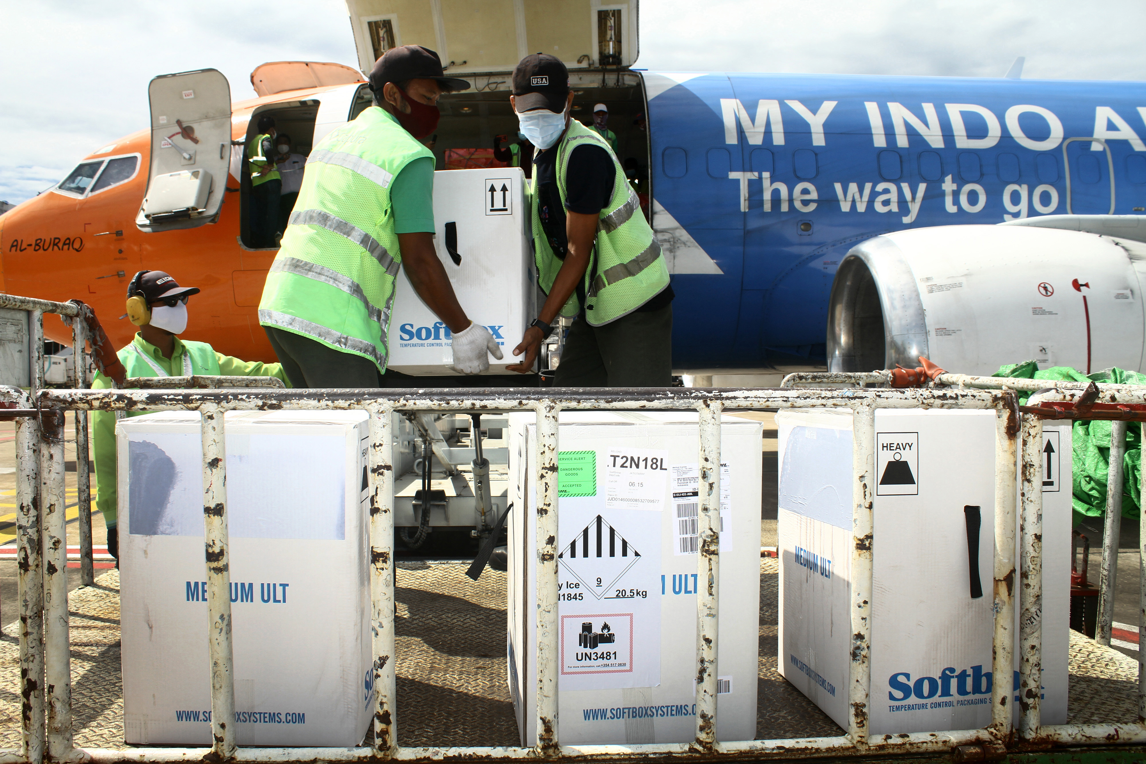 Petugas mengangkat kotak berisi vaksin Pfizer sesaat setelah tiba di Bandara Supadio di Kabupaten Kubu Raya, Kalimantan Barat, Sabtu (2/10)