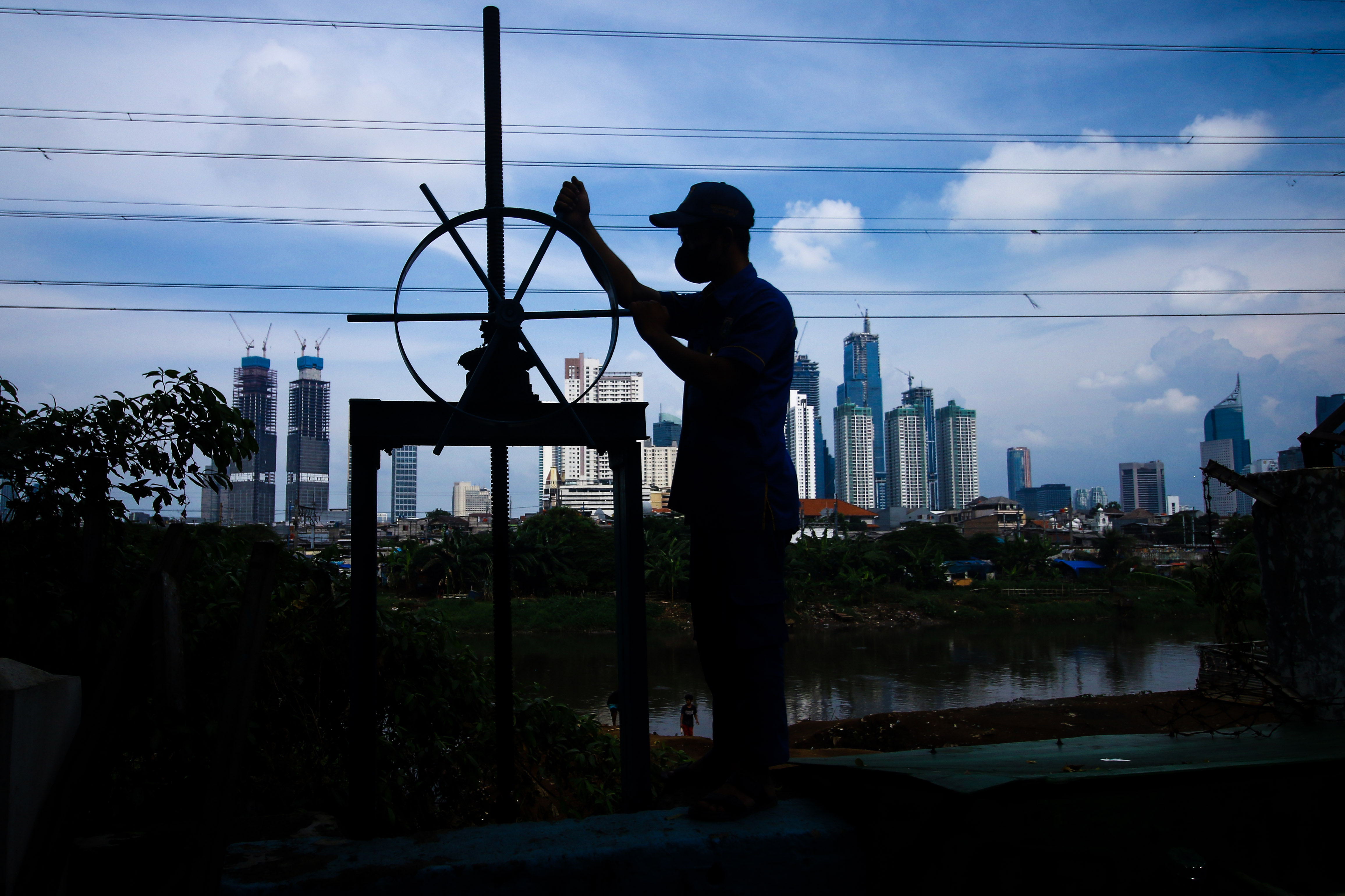  Petugas Suku Dinas Sumber Daya Air Jakarta Pusat mengecek pintu air Petambutan II, Jakarta untuk mengantisipasi ancaman banjir.