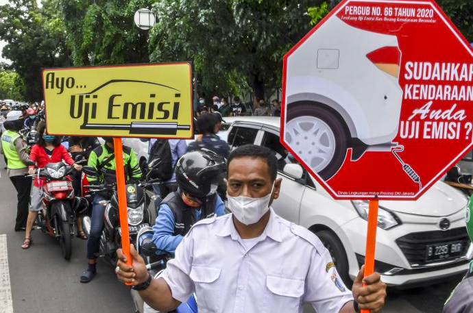 Petugas sosialisasikan pemeriksaan uji emisi gas buang kendaraan bermotor di Jalan Pemuda, Jakarta. 