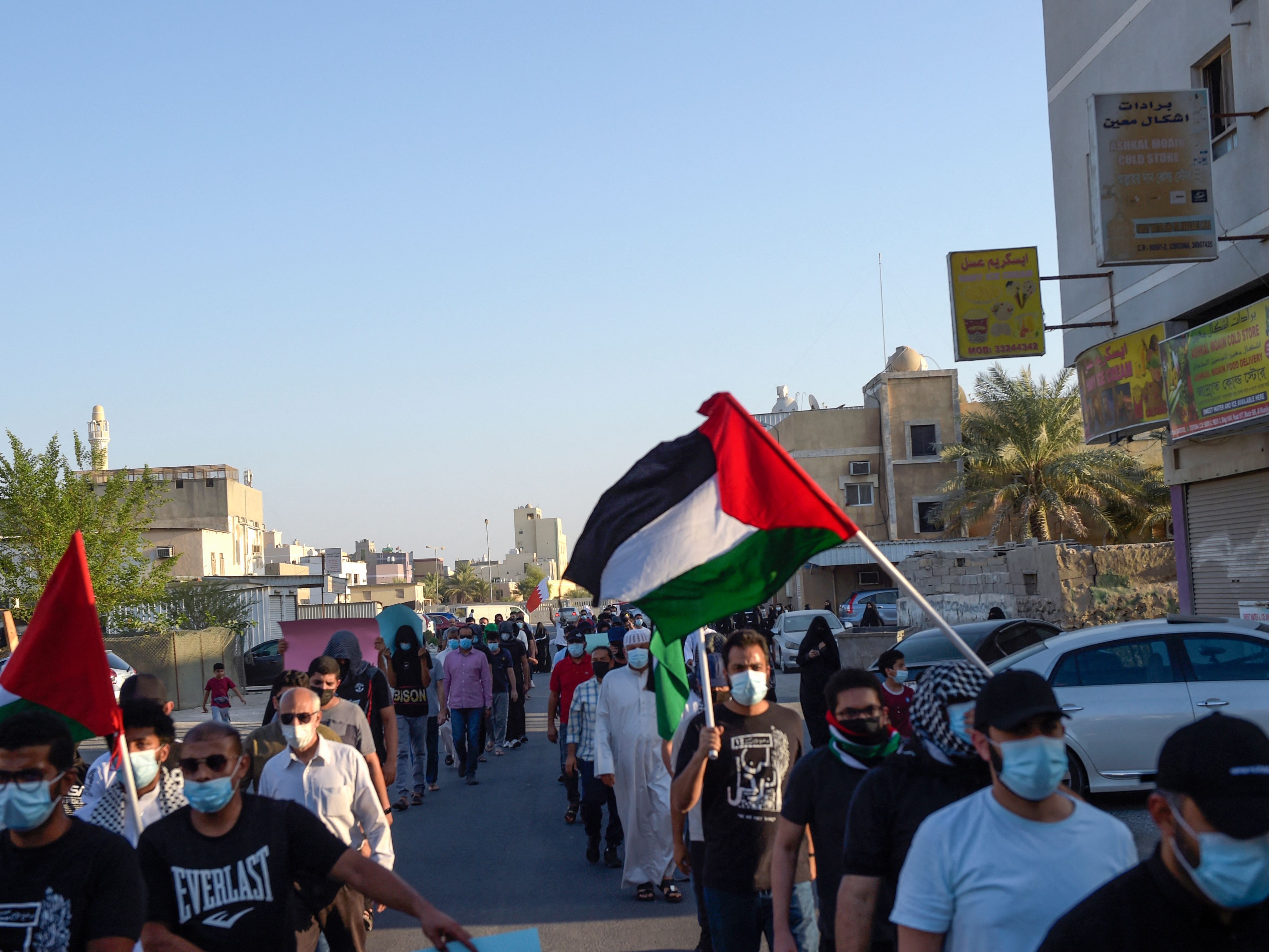 Para pengunjuk rasa mengangkat bendera Bahrain dan Palestina selama demonstrasi anti-Israel di pulau Sitra, selatan ibu kota Bahrain.