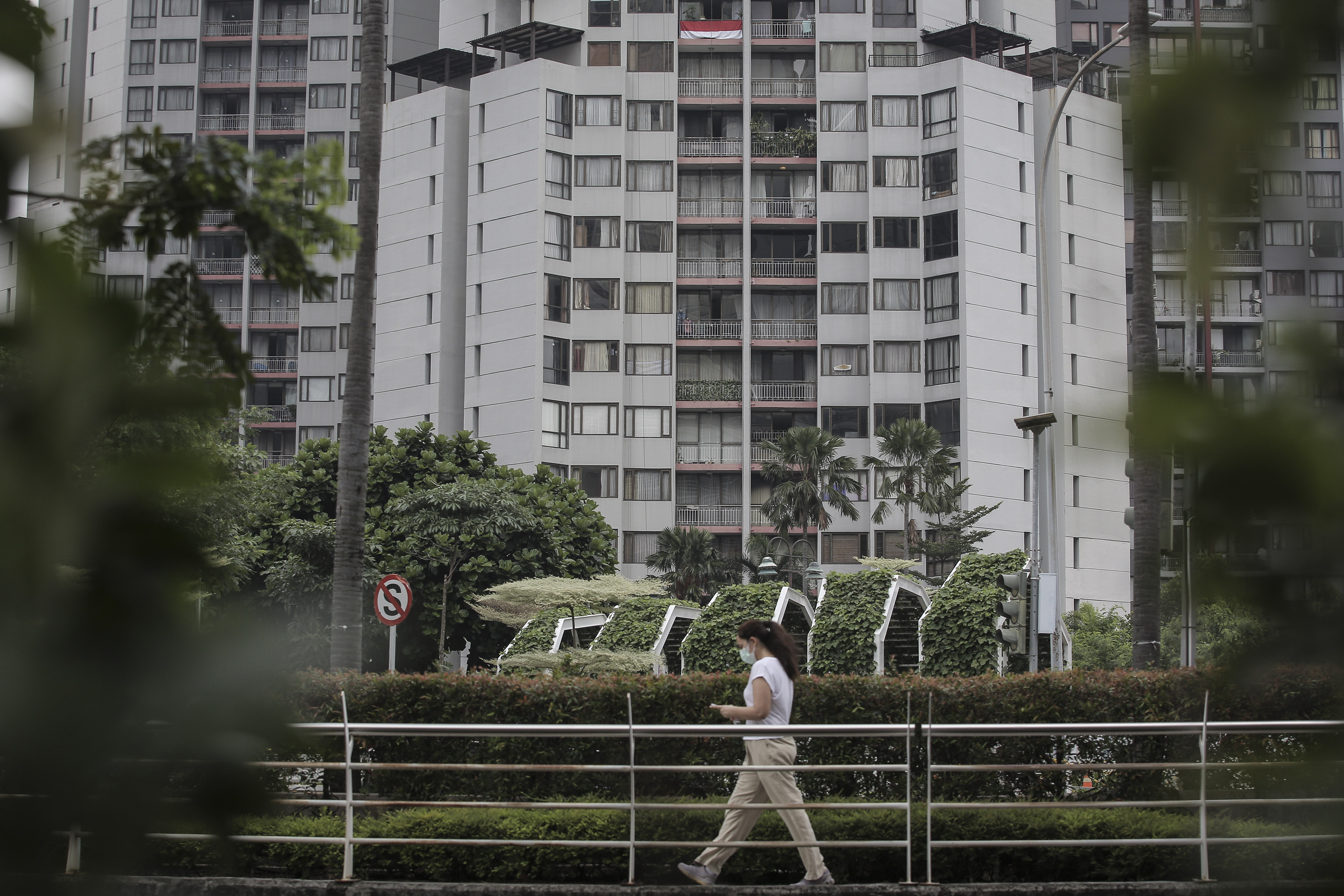  Seorang warga berjalan di dekat sebuah apartemen di kawasan Kuningan, Jakarta.
