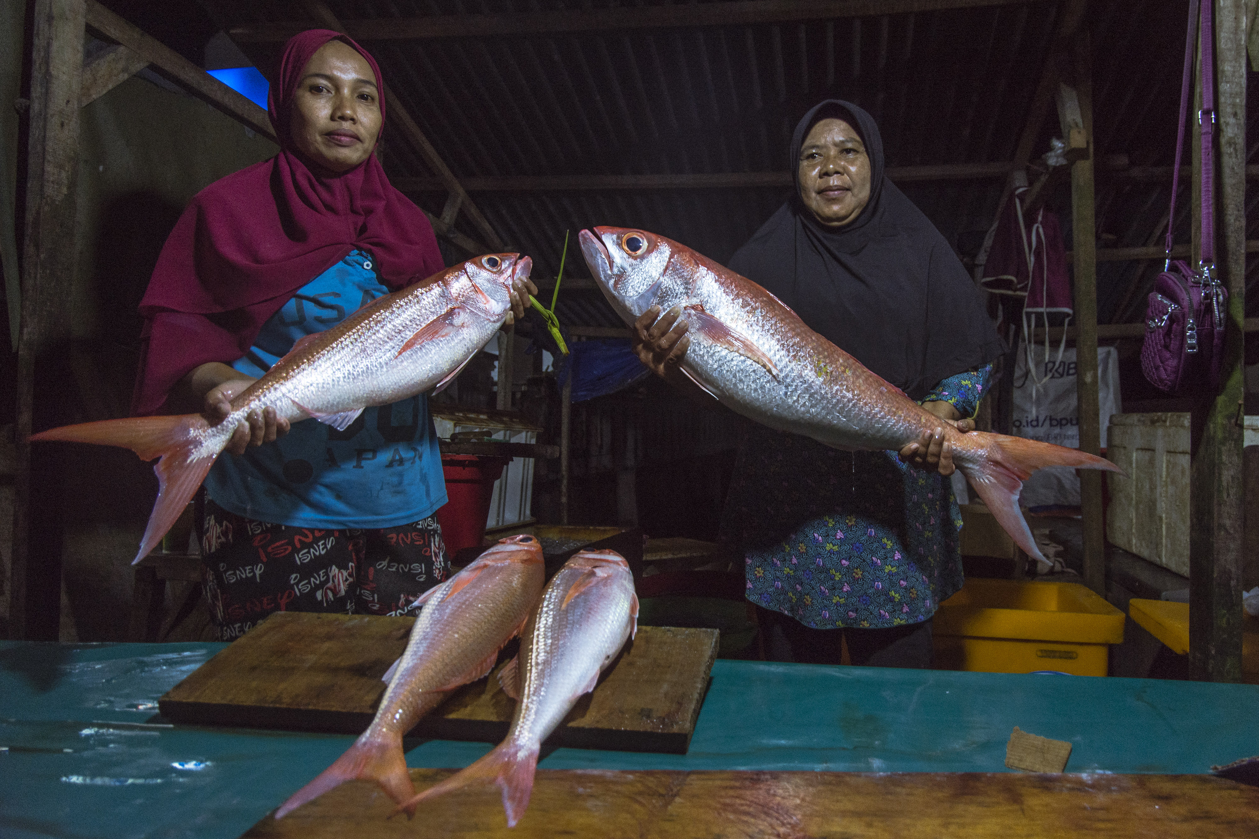 Pedagang menunjukkan ikan segar di Pasar Ikan Tulehu, Maluku