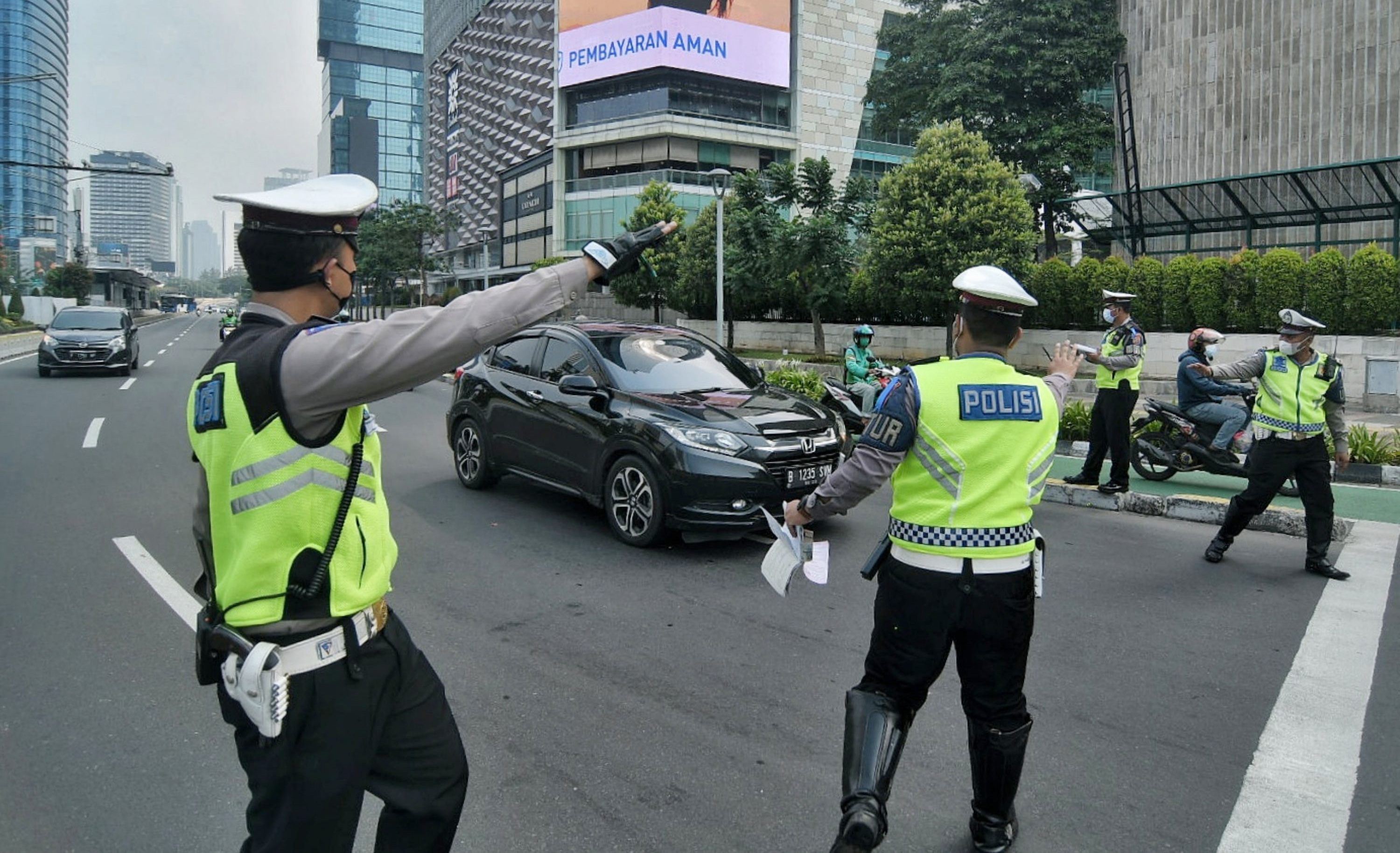 Polisi menindak pengendara saat Operasi Patuh Jaya 2021 di kawasan Bundaran Hotel Indonesia, Jakarta.