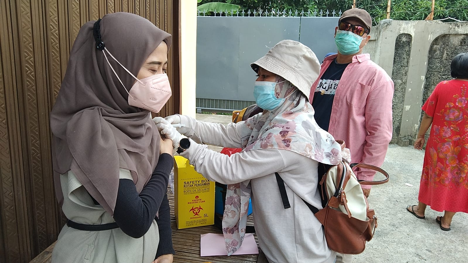 Seorang warga Pondokgede menerima suntikan vaksin covid-19.