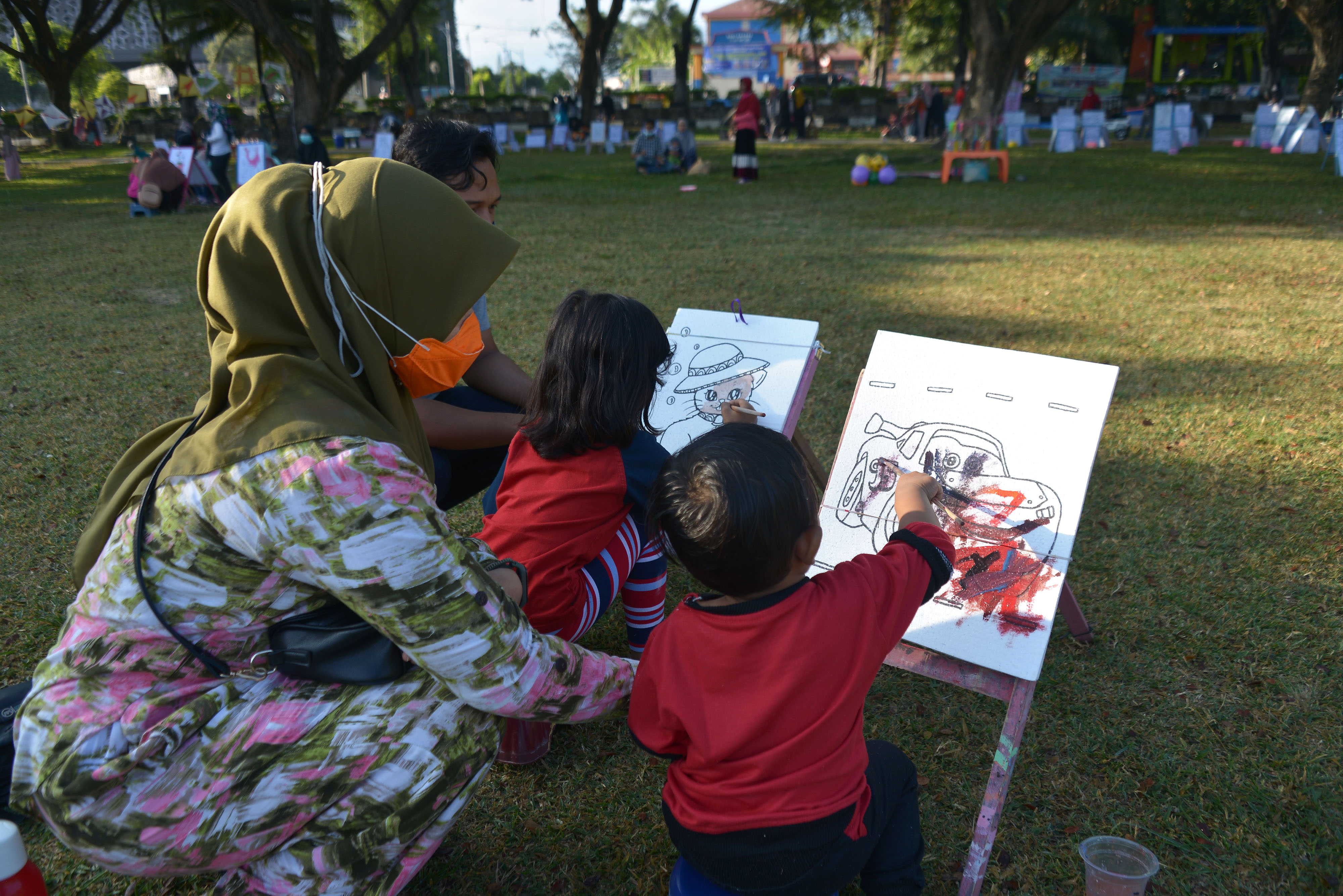KOTA LAYAK ANAK: Seorang ibu mendapingi anaknya mengikuti kegiatan mewarnai di area bermain publik, Lapangan Blang Padang, Banda Aceh.