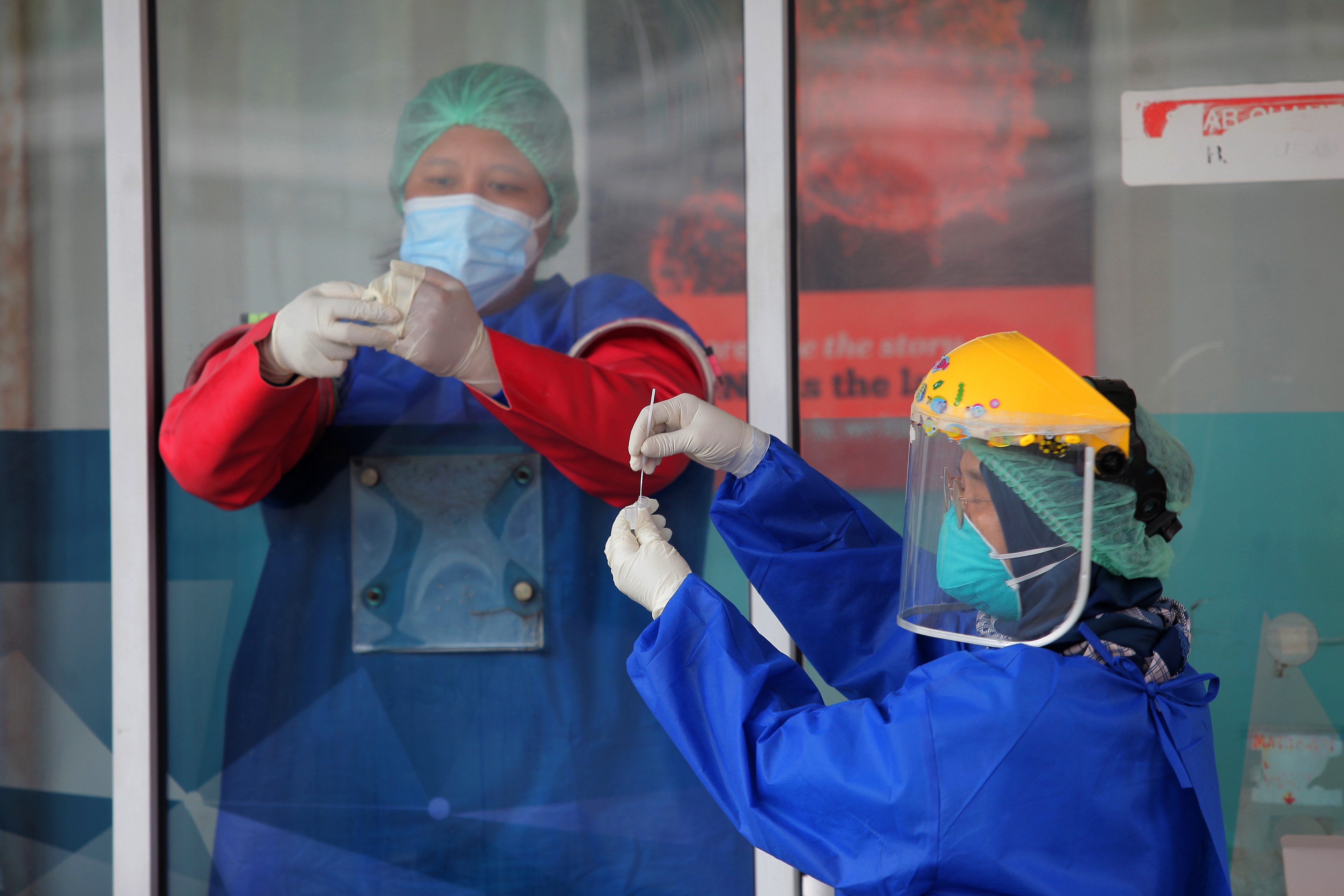 Petugas medis memasukkan hasil tes usap dengan sistem PCR ke dalam tabung.