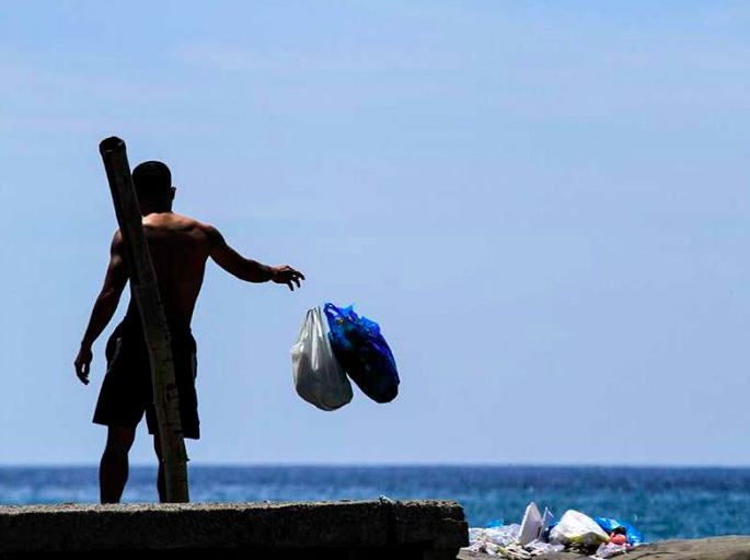 Warga membuang sampah rumah tangga ke area pesisir pantai Kampung Jawa, Lhokseumawe, Aceh, Sabtu (2/6). 