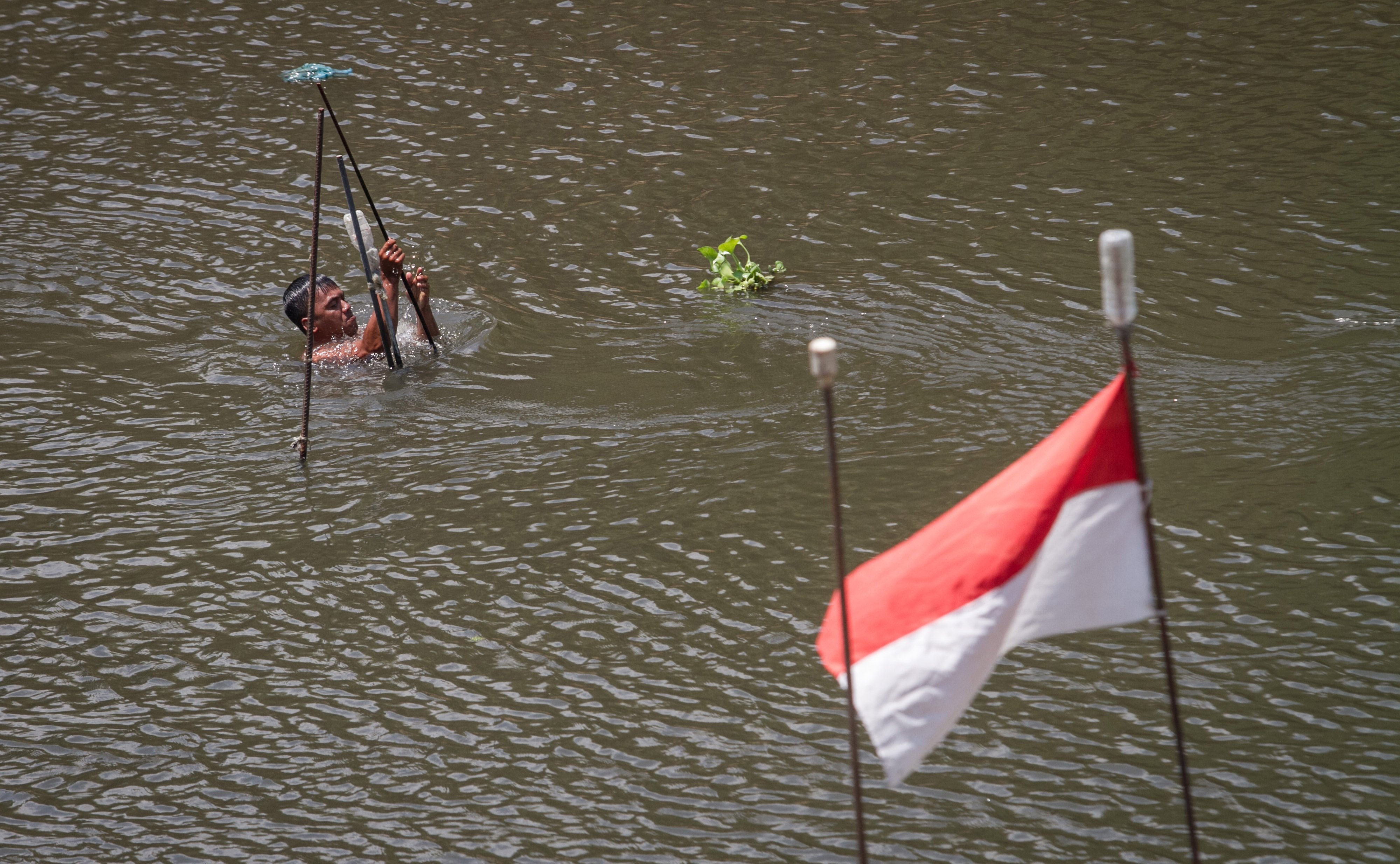 Ilustrasi karyawan memeriksa pompa air Sungai Bengawan Solo untuk instalasi pengolahan air.