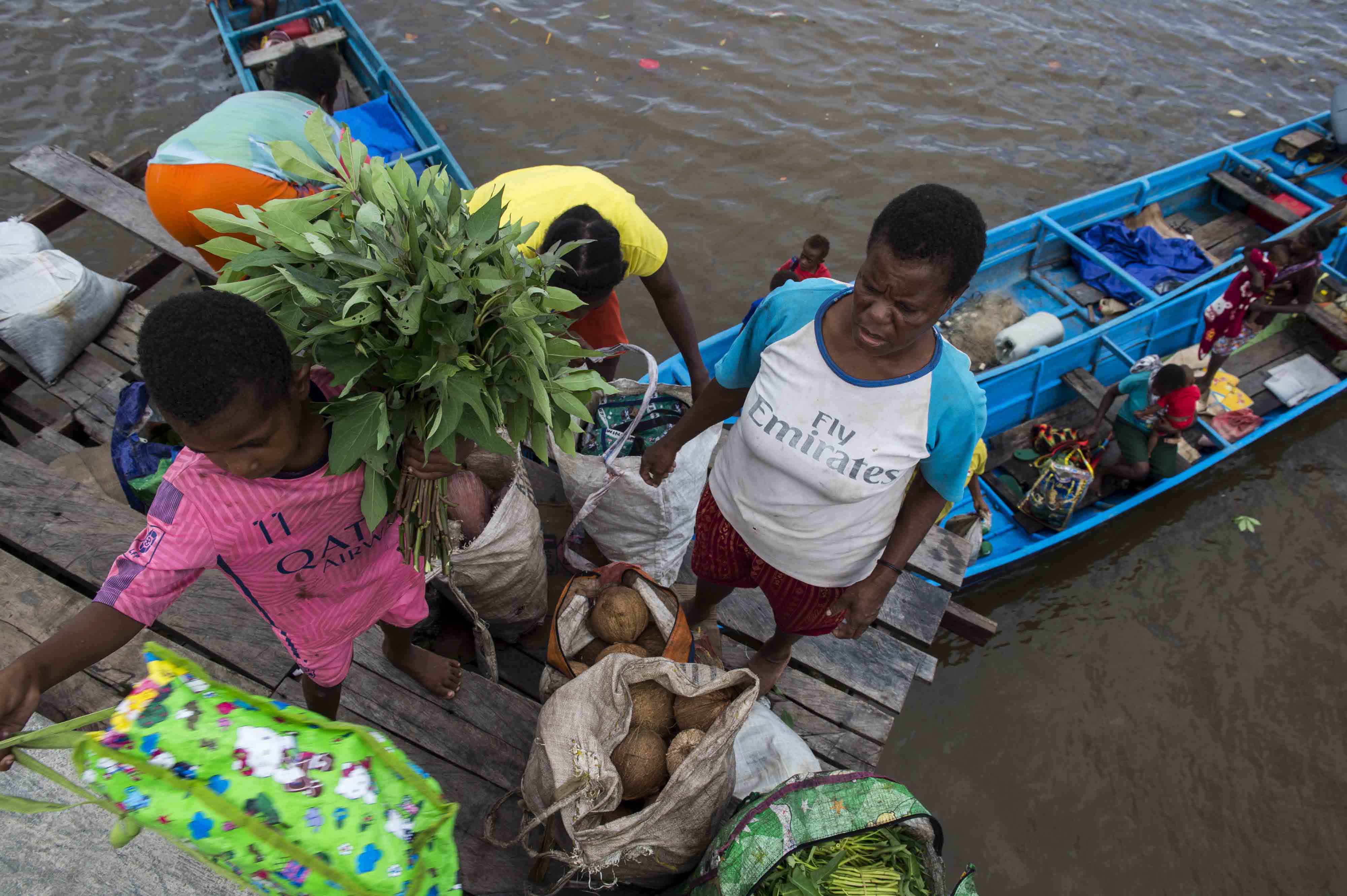 Seorang ibu dan anak membawa sayur di dermaga wilayah Kabupaten Asmat, Papua.