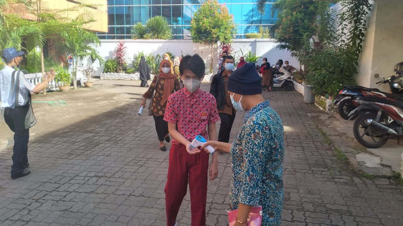 Seorang siswa SD menjalani tes suhu sebelum mengikuti PTM Terbatas di Kota Makassar, Kamis (4/11).  