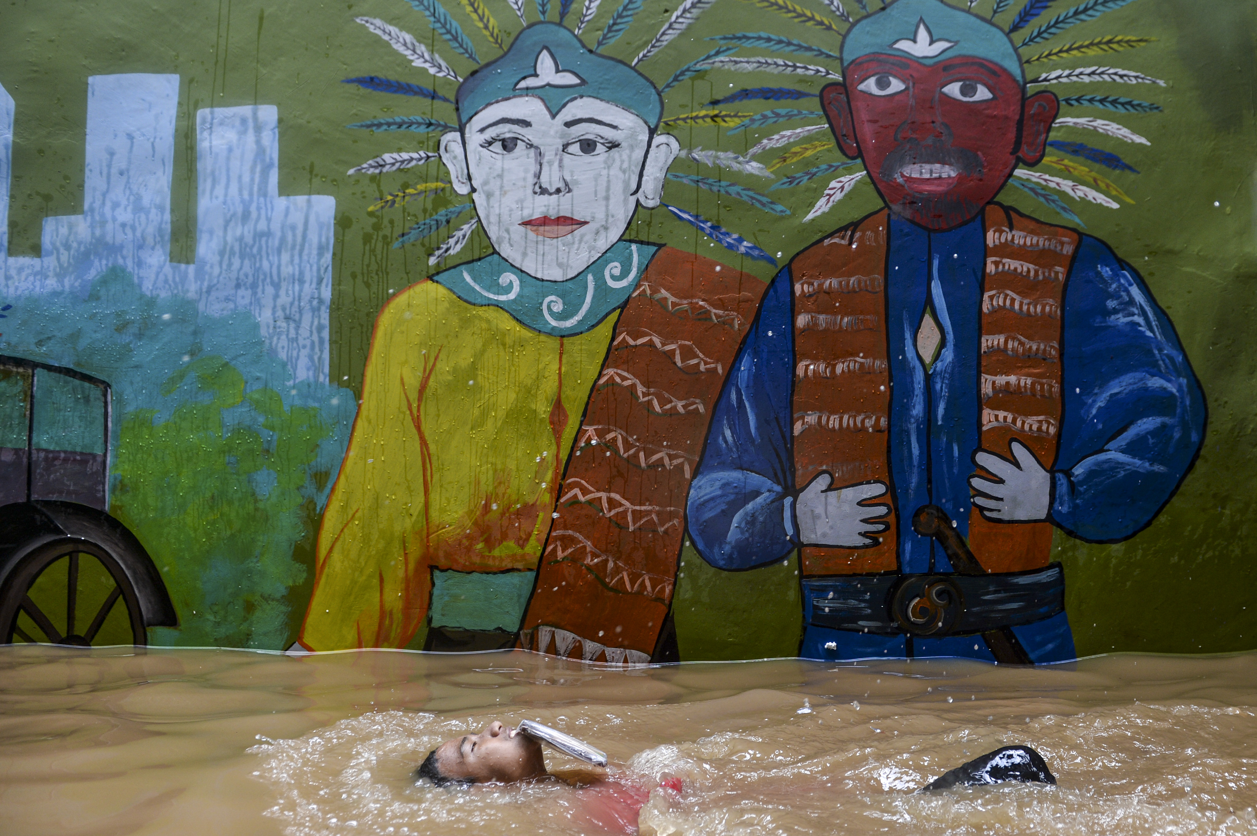  Seorang warga berenang ketika banjir merendam di kawasan Kebon Pala, Kampung Melayu, Jatinegara, Jakarta Timur, Senin (8/11/2021).