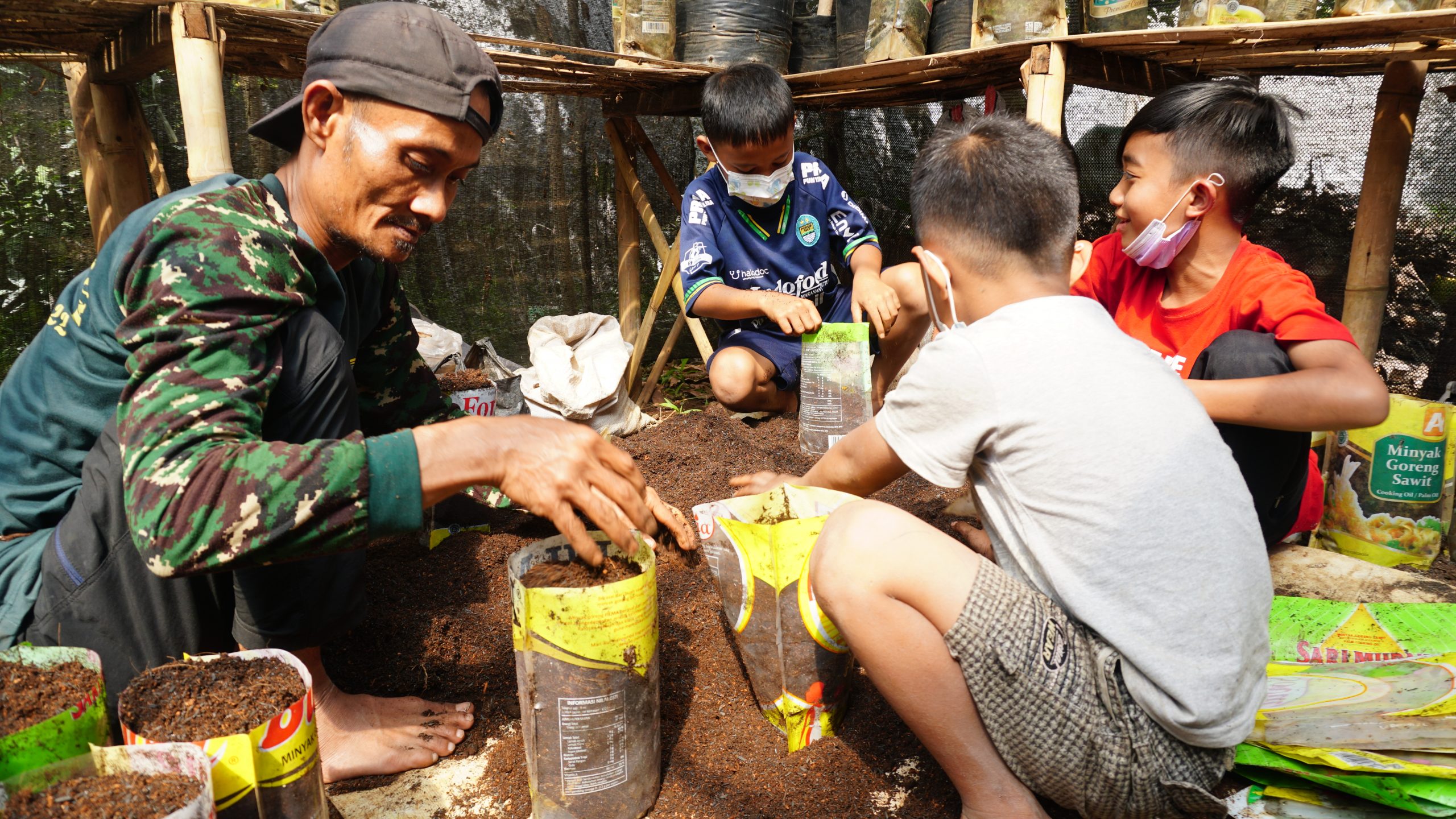 Mang Dian menumbuhkan benih bersama sejumlah anak.