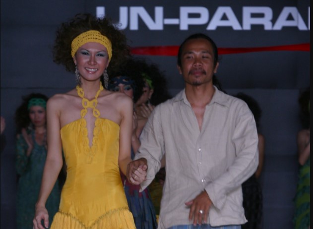 Perancang busana Ali Charisma (kanan) berjalan bersama model dalam sebuah pagelaran busana.