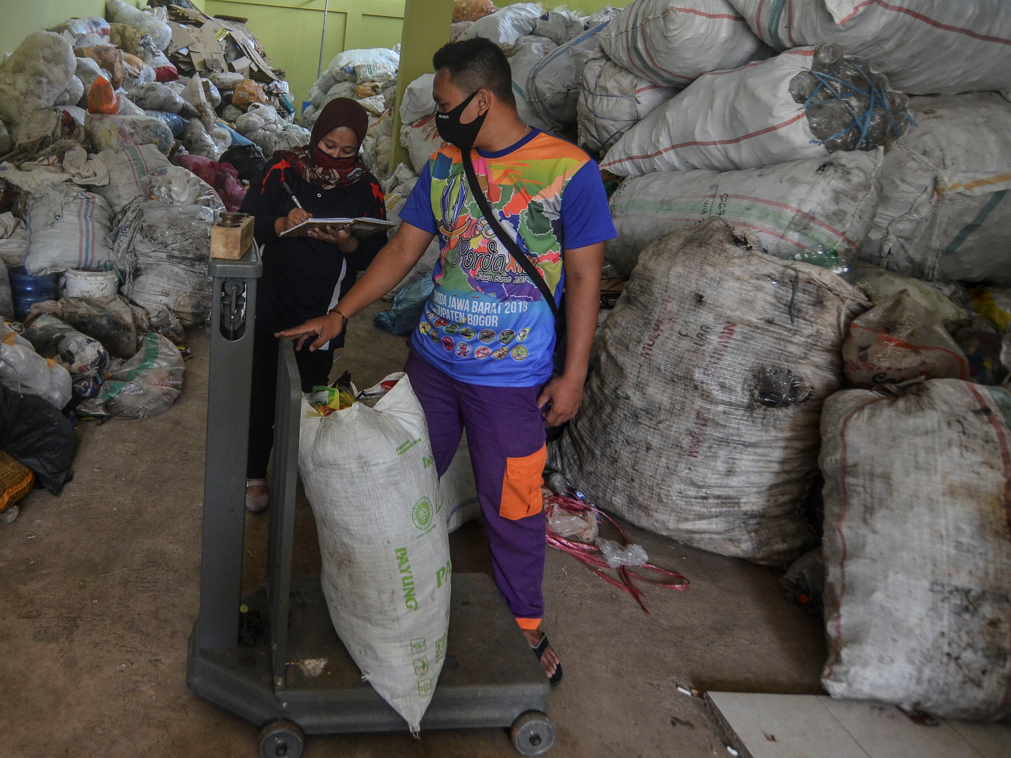Pegawai bank sampah menimbang sampah plastik kiriman nasabahnya di gudang Bank Sampah Ciamis, Kabupaten Ciamis, Jawa Barat.