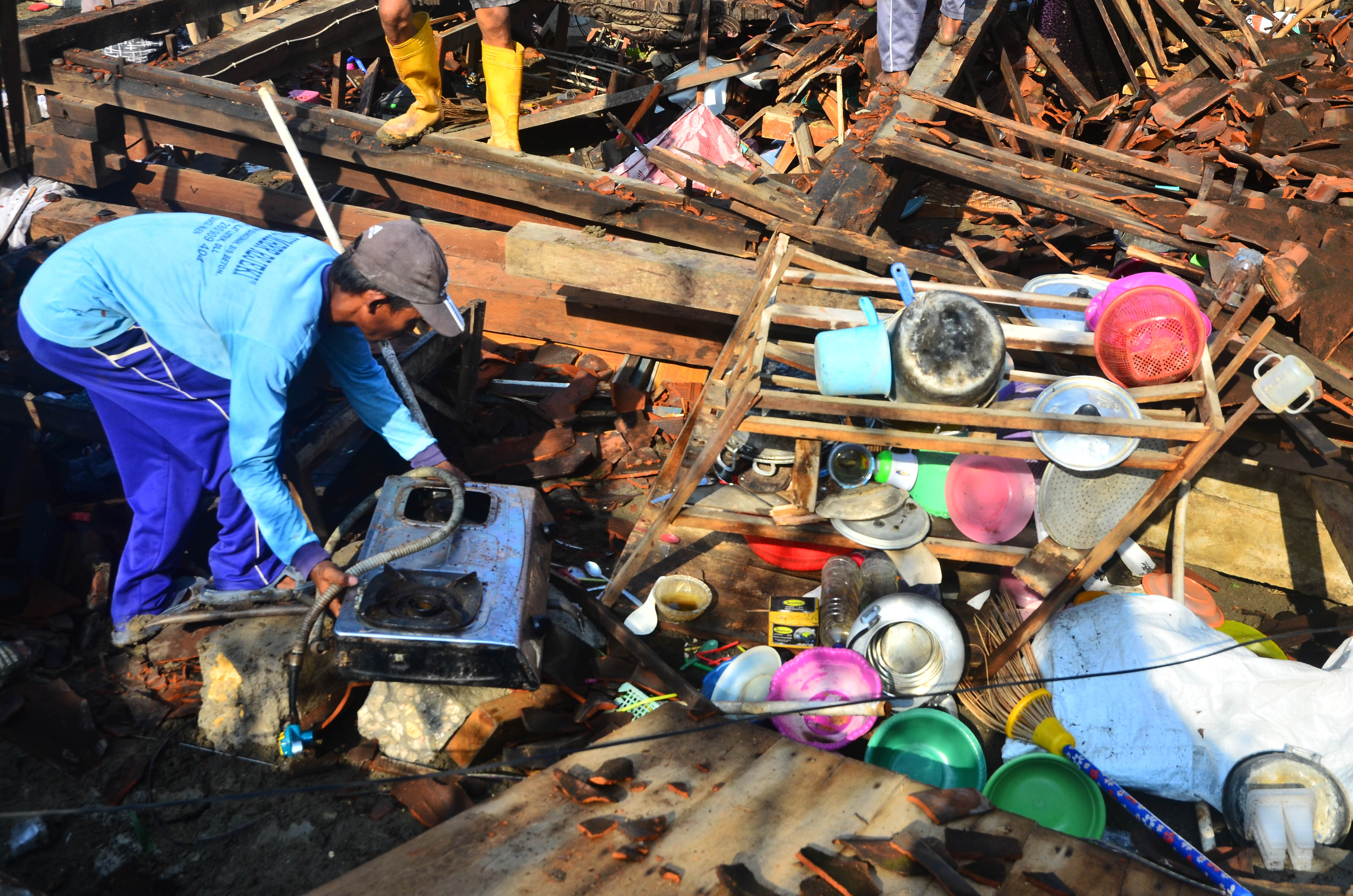Warga menyelamatkan barang dari rumah roboh akibat angin puting beliung di Desa Karanggeneng, Grobogagan,  Jawa Tengah, Selasa  (26/10/2021)