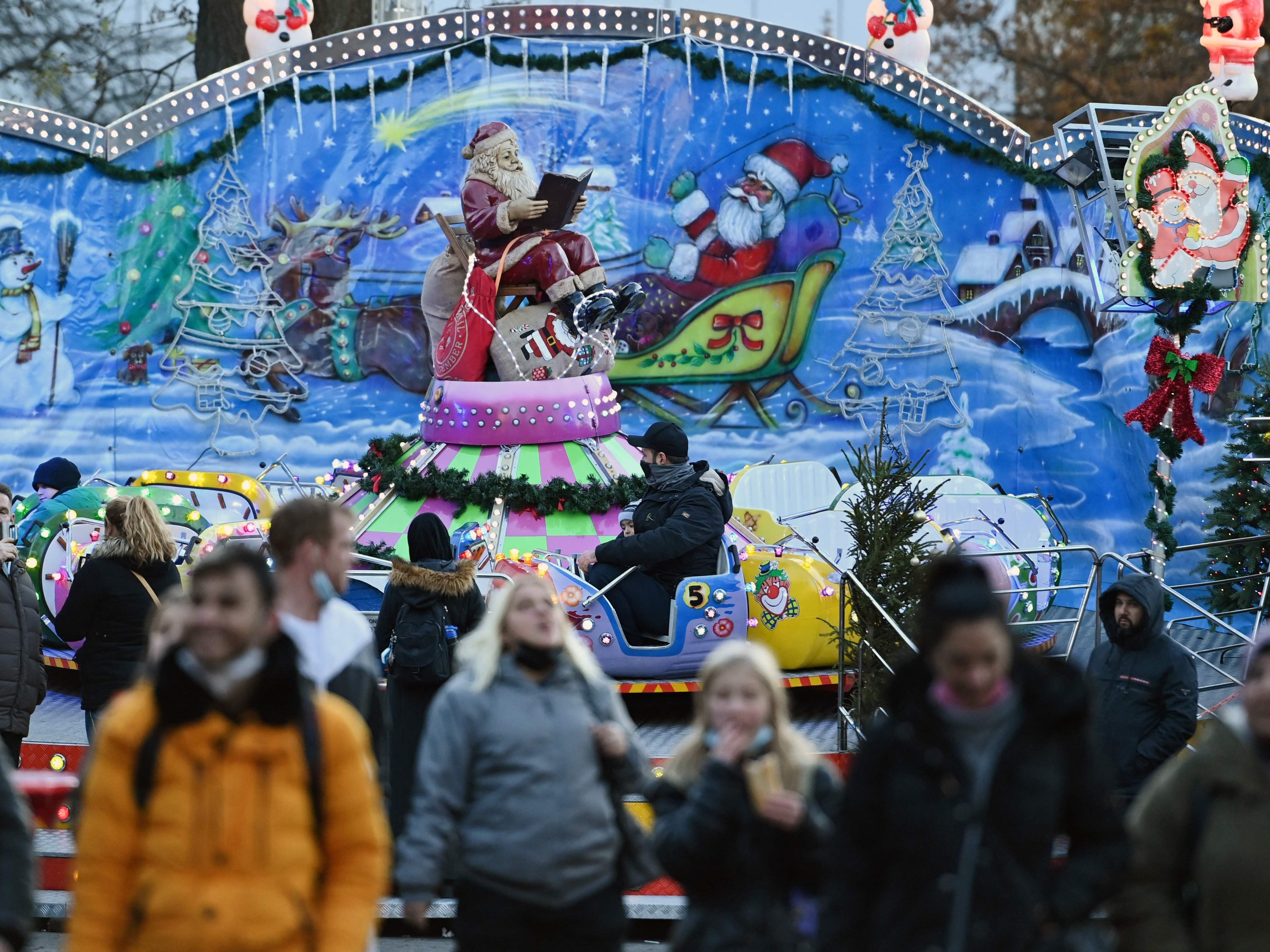 Pengunjung berjalan melewati suatu stan di pasar Natal di Hagen, Jerman barat, pada 22 November 2021.