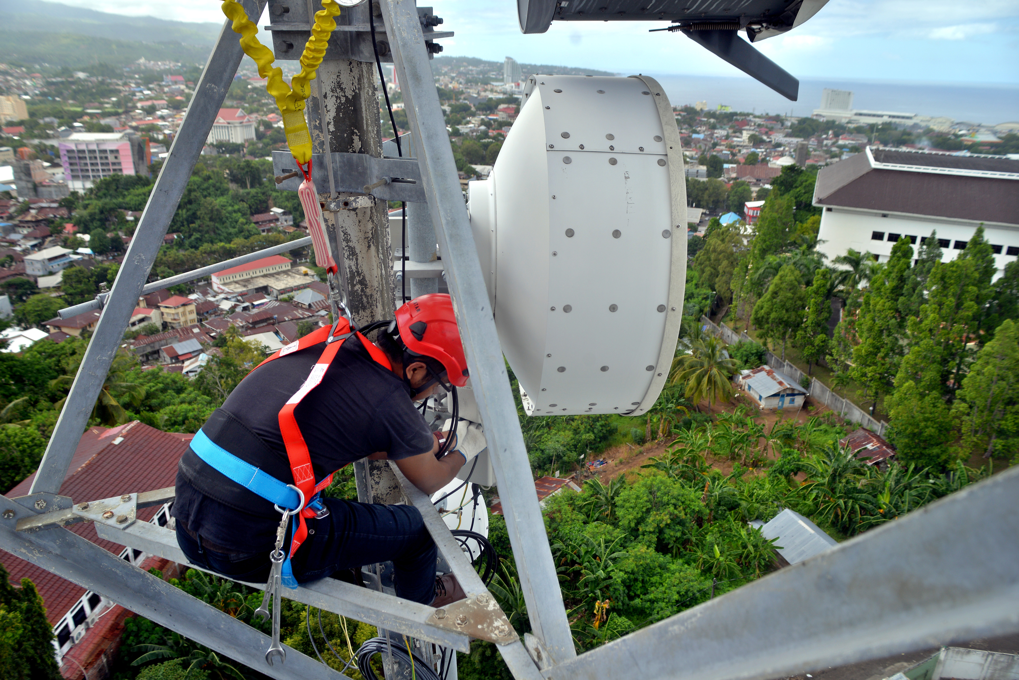 Petugas memastikan jaringan di tower telekomunikasi.