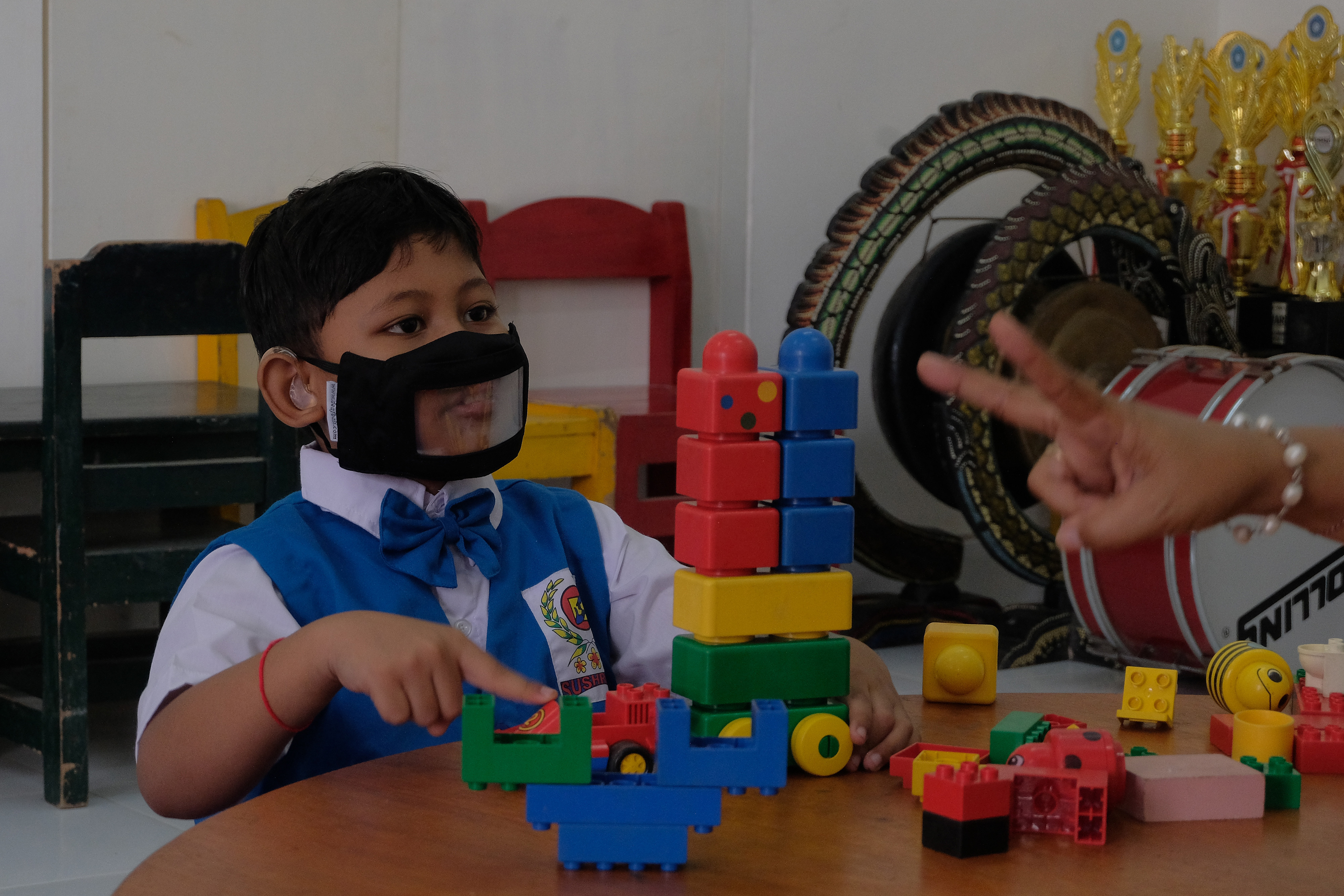 Guru berkomunikasi dengan bahasa isyarat kepada siswa TK penyandang difabel yang mengikuti pembelajaran tatap muka (PTM) terbatas.