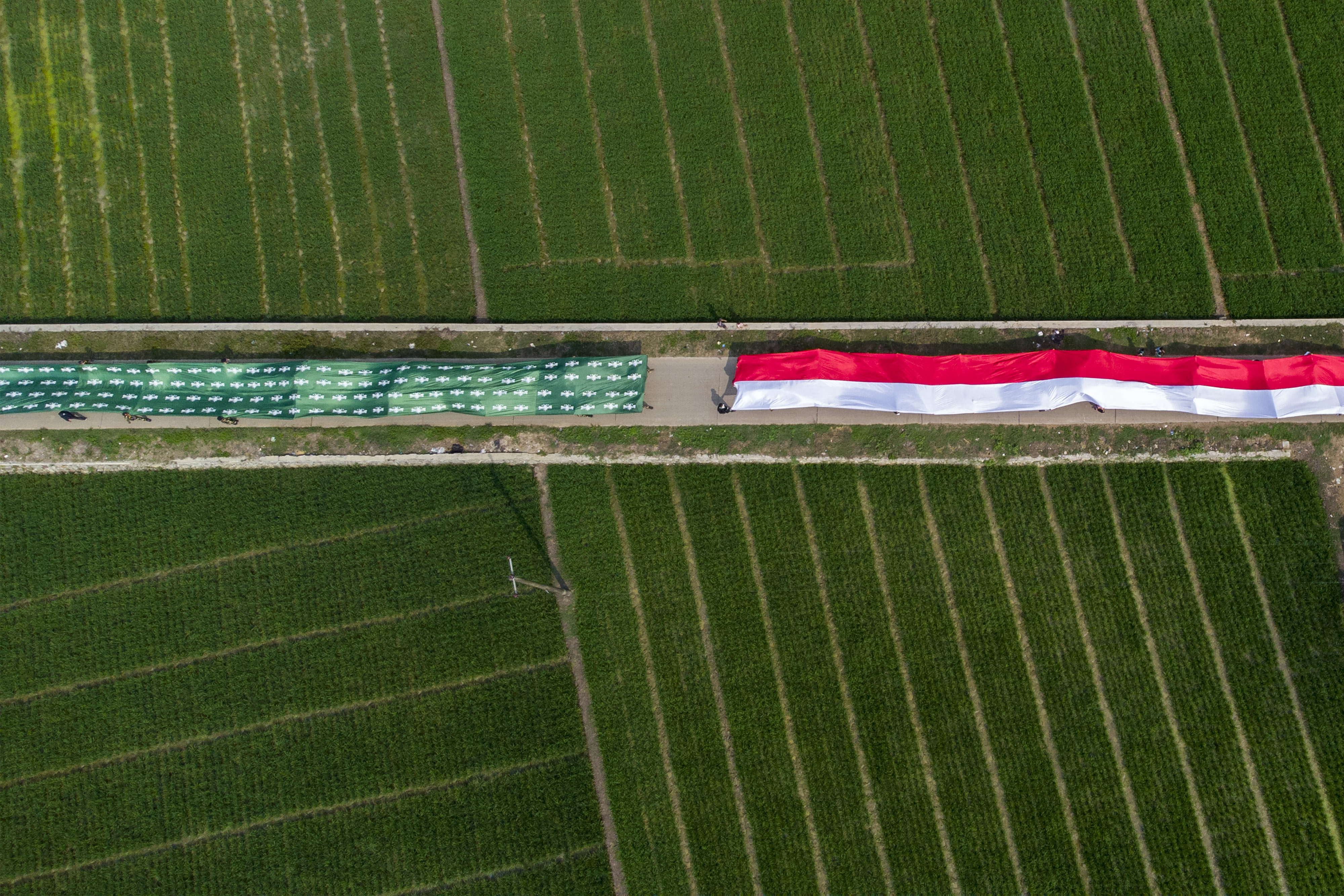 Foto udara kirab santri membawa bendera Merah Putih dan Nahdlatul Ulama di Desa Ciwulan, Telagasari, Karawang, Jawa Barat, belum lama ini.