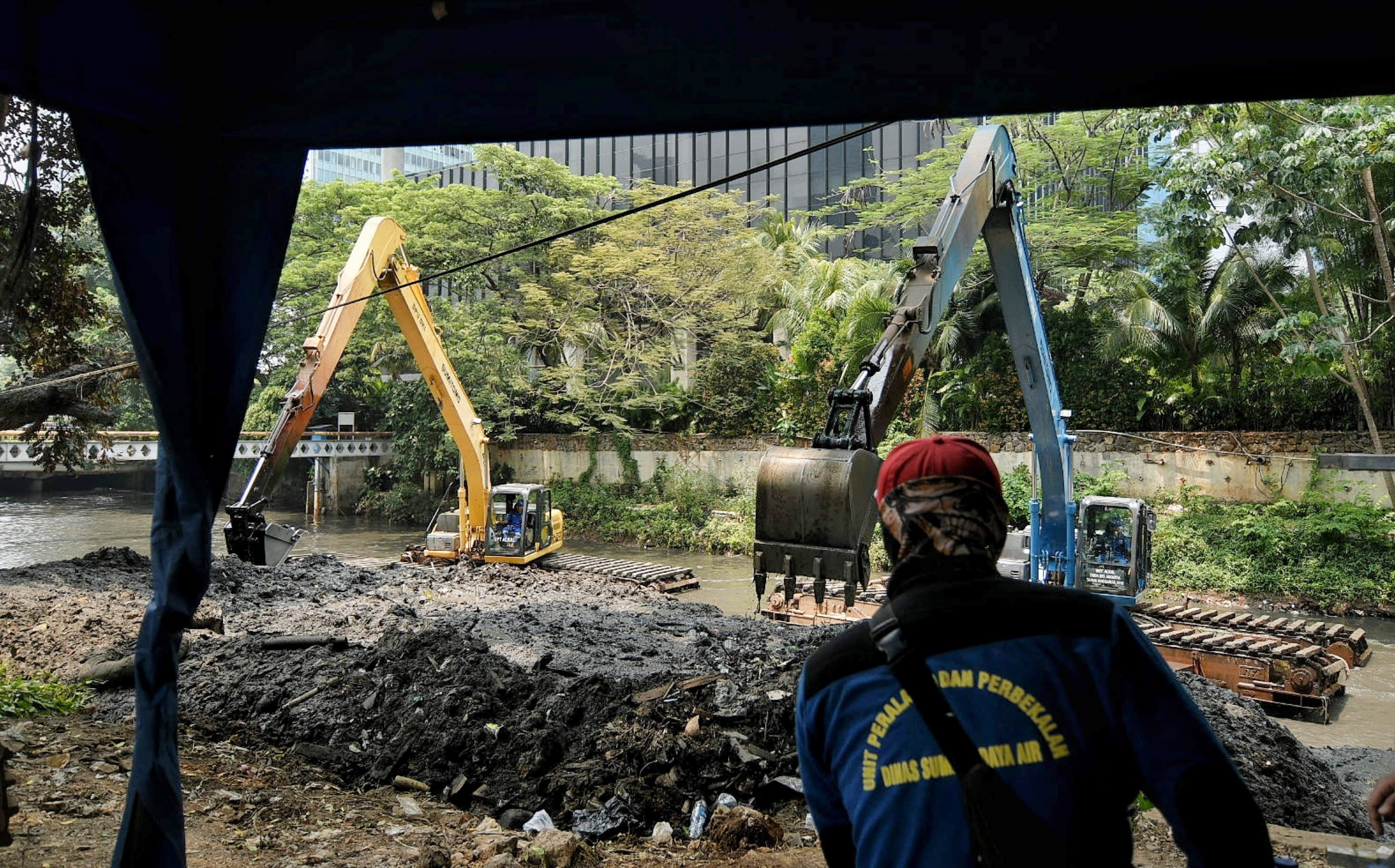 Petugas melakukan pengerukan lumpur