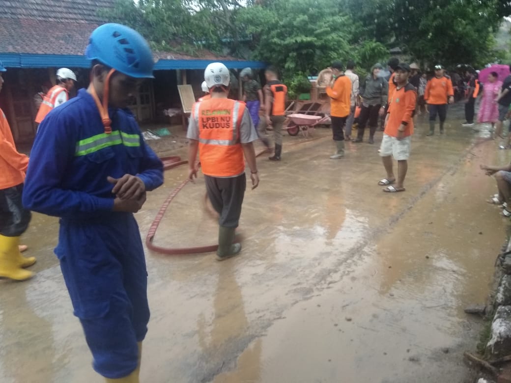 TNI/Polri, relawan tanggap bencana di Kudus membersihkan material lumpur yang terbawa banjir bandang di Desa Wonosoco, Kecamatan Undaan, Rab