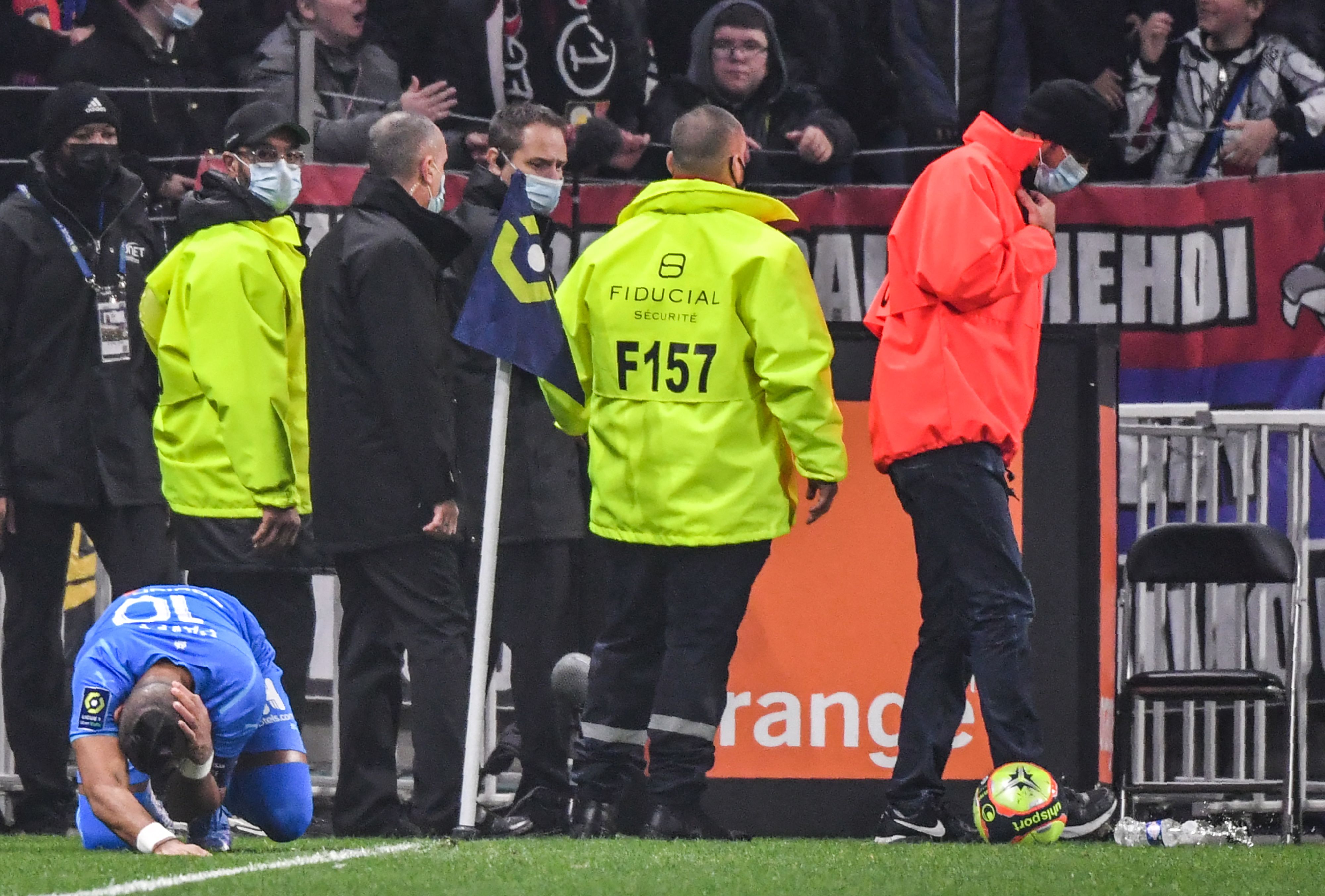 Pemain Marseille Dimitri Payet terjatuh setelah terkena lemparan botol dari pendukung Lyon di laga Ligue 1.