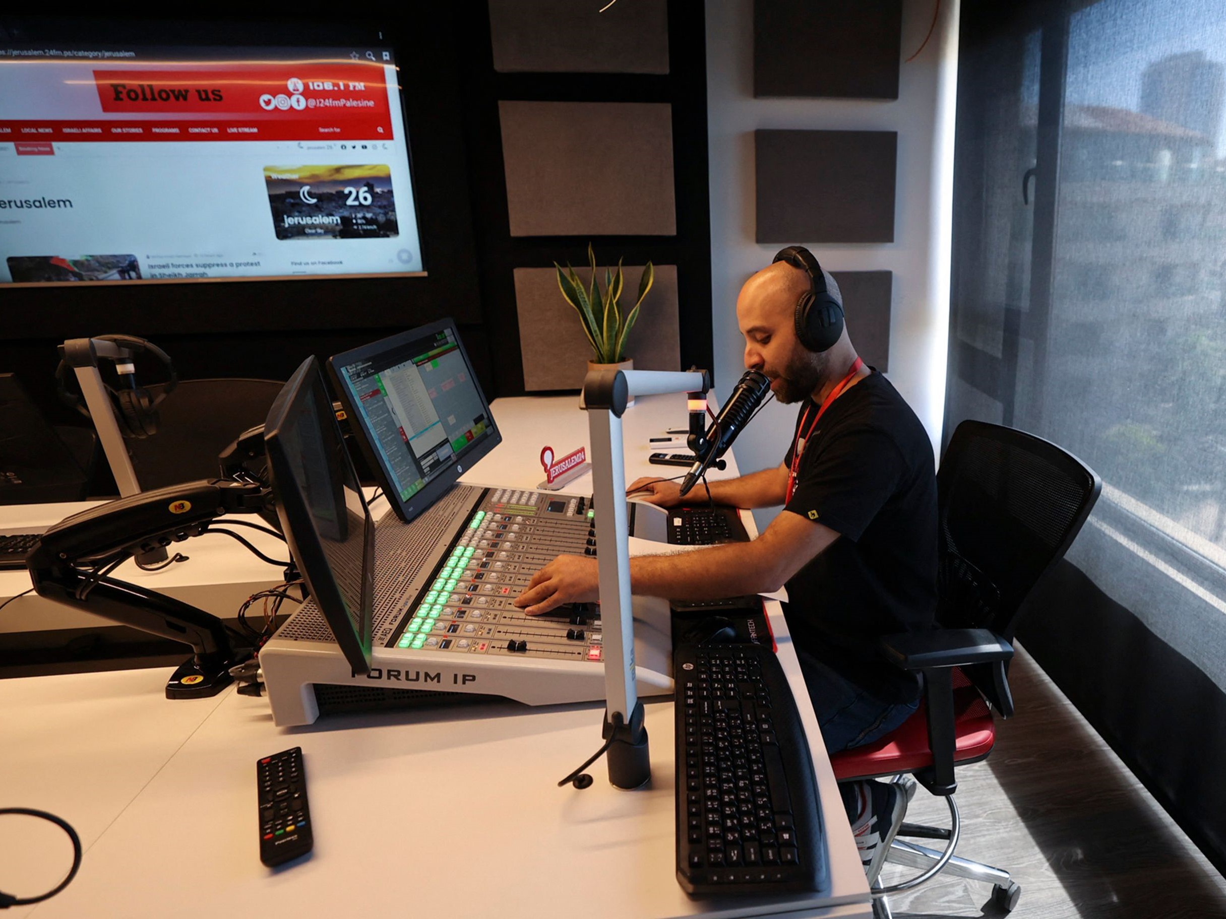 Seorang karyawan bekerja di stasiun radio Jerusalem 24 yang baru diluncurkan di kota Ramallah di Tepi Barat yang diduduki Israel.