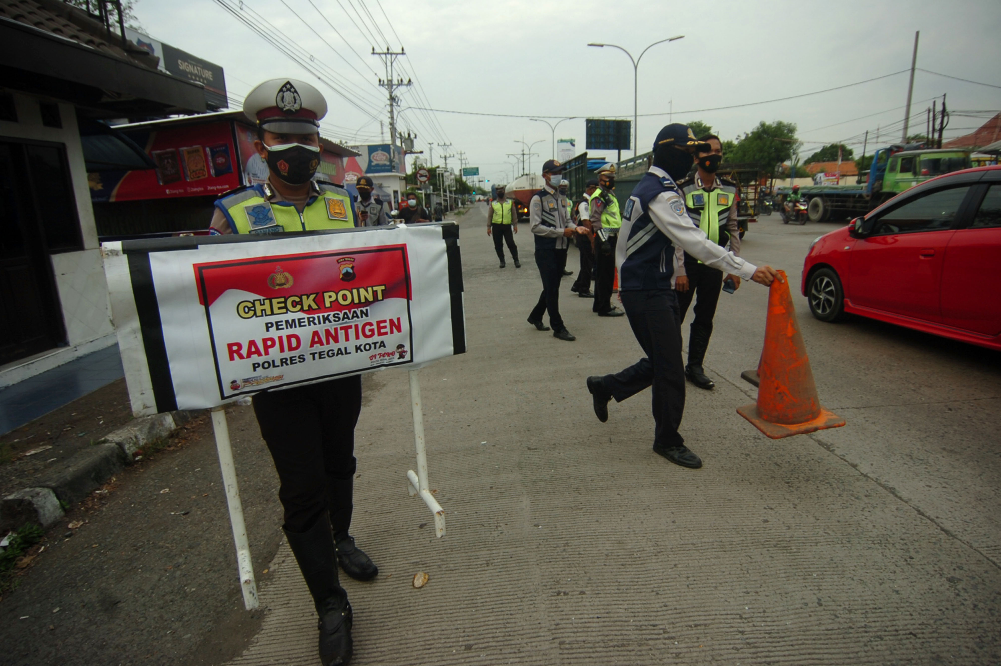 Personel kepolisian bersiap melakukan penyekatan PPKM Darurat di jalur Pantura, Tegal, Jawa Tengah.