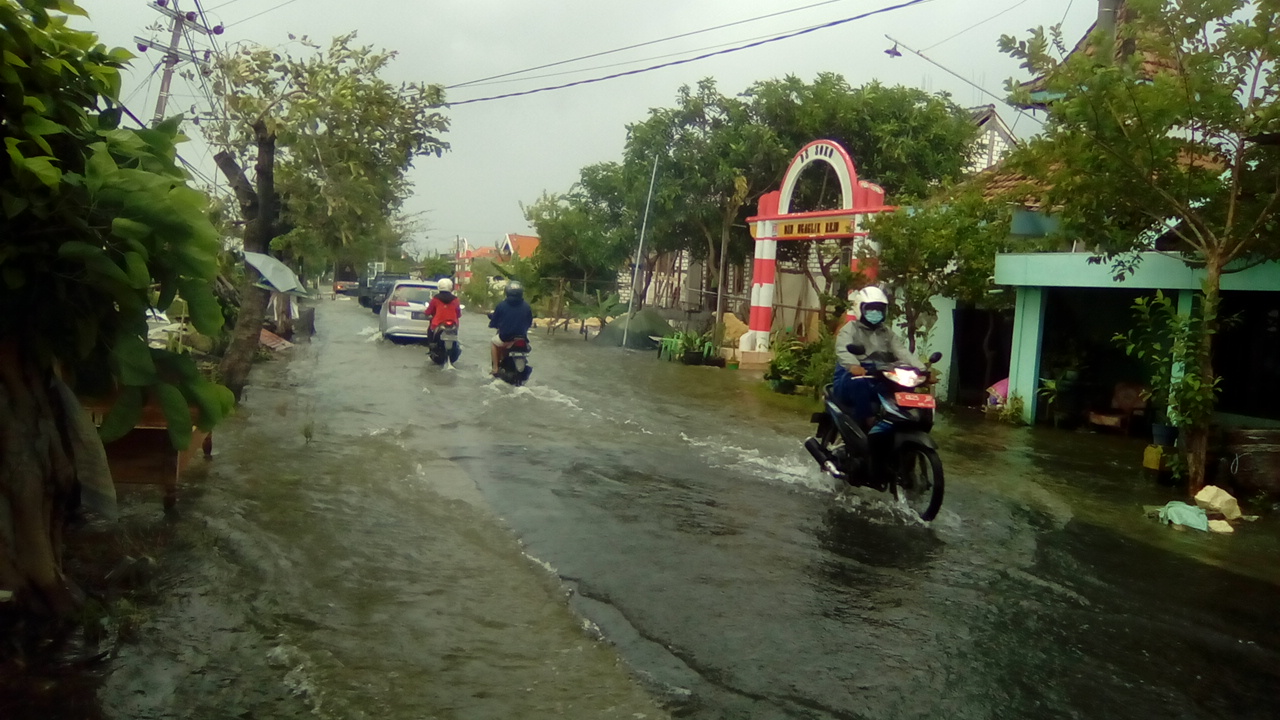 Banjir di jalan raya akibat jebolnya tanggul anak Sungai Bengawan Solo