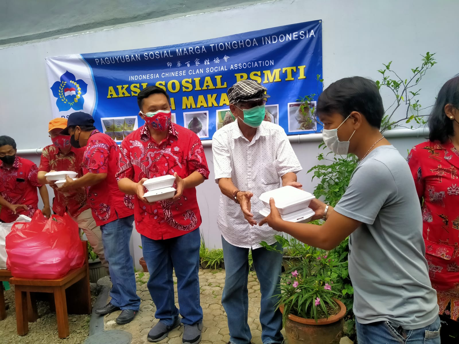 Pengurus Paguyuban Sosial Marga Tionghoa Indonesia (PSMTI) tengah membagikan nasi bungkus kepada masyararakat.