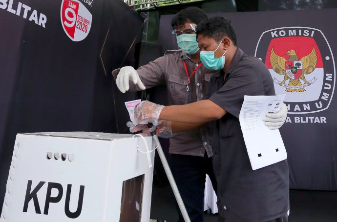 Petugas KPPS membantu pemilih khusus disabilitas menjalani proses pemungutan suara saat simulasi pemungutan suara.