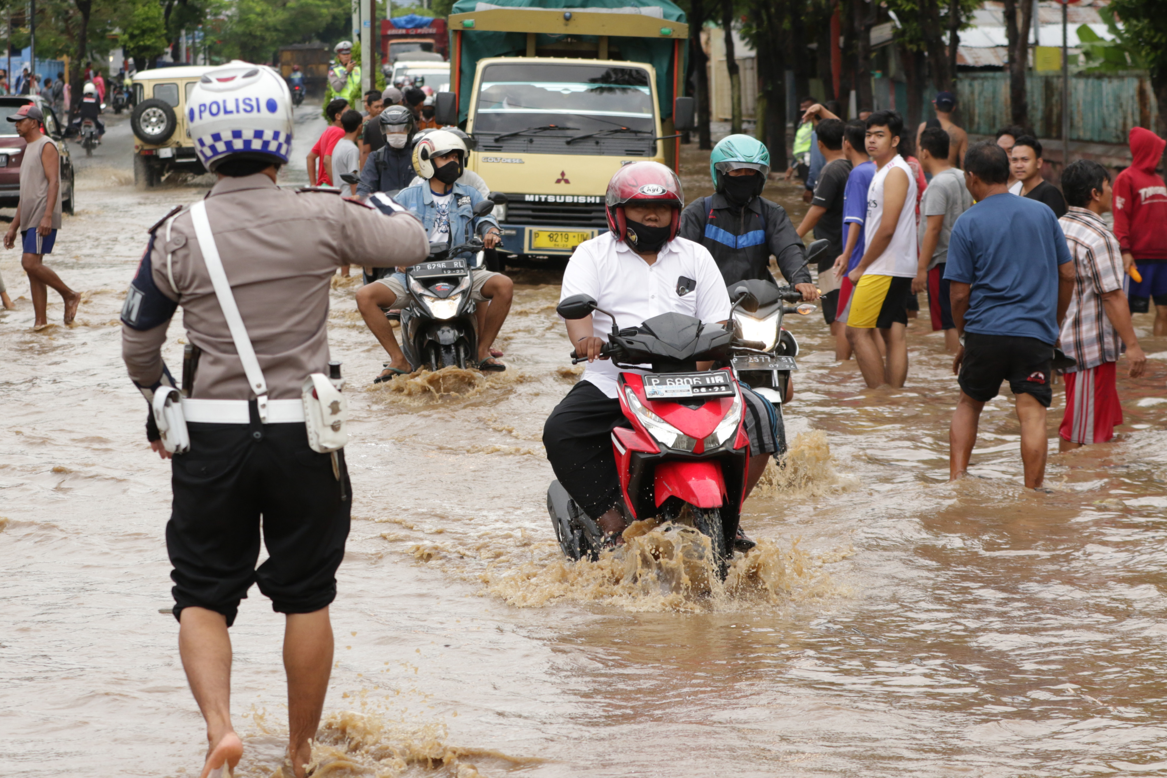 Warga menerobos banjir yang menggenangi jalan S Parman, Banyuwangi, Jawa Timur