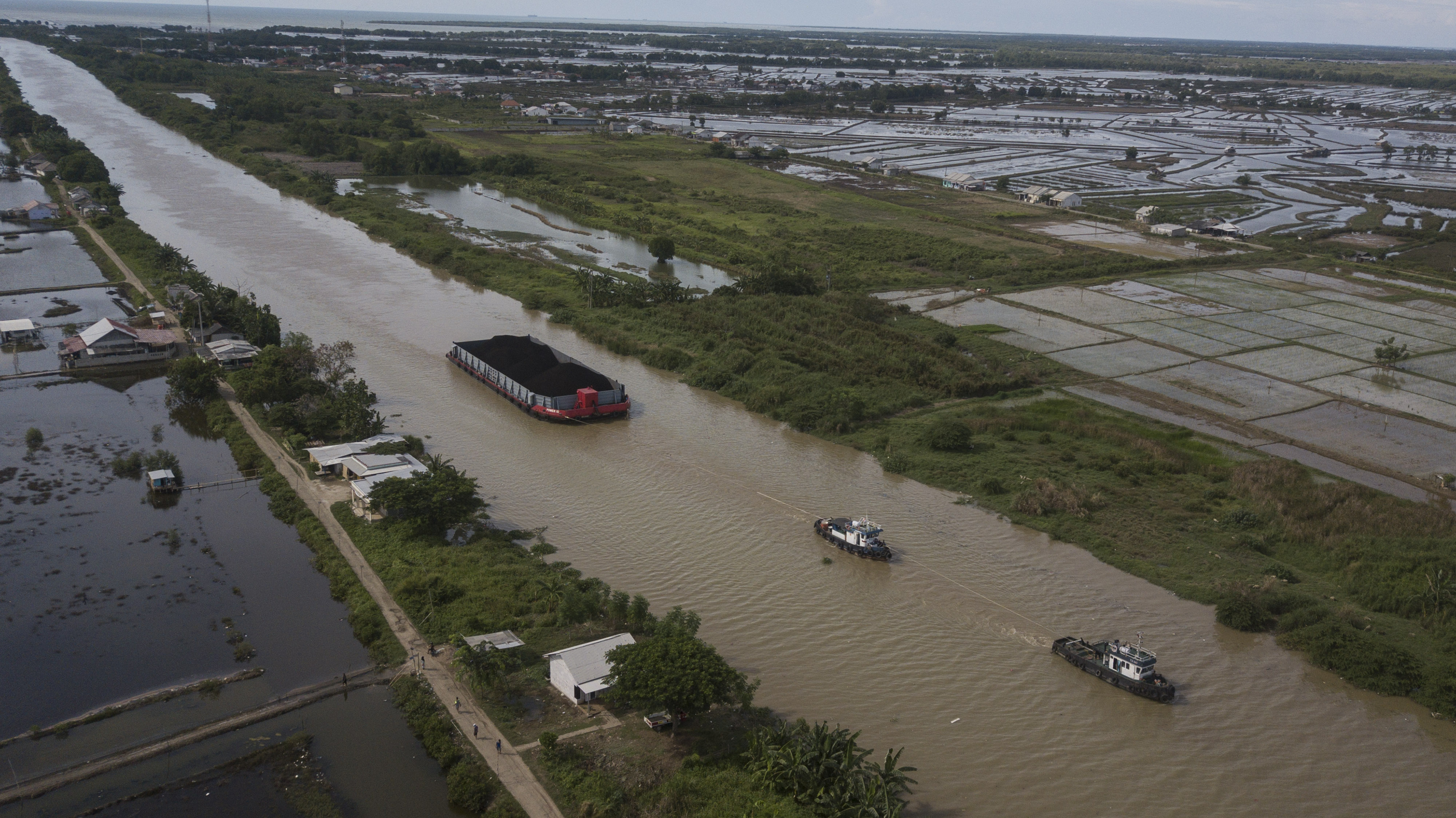  Foto udara Kapal tongkang pengangkut batu bara melintas di kali CBL (Cikarang Bekasi Laut), Tarumajaya, Kabupaten Bekasi, Jawa Barat.