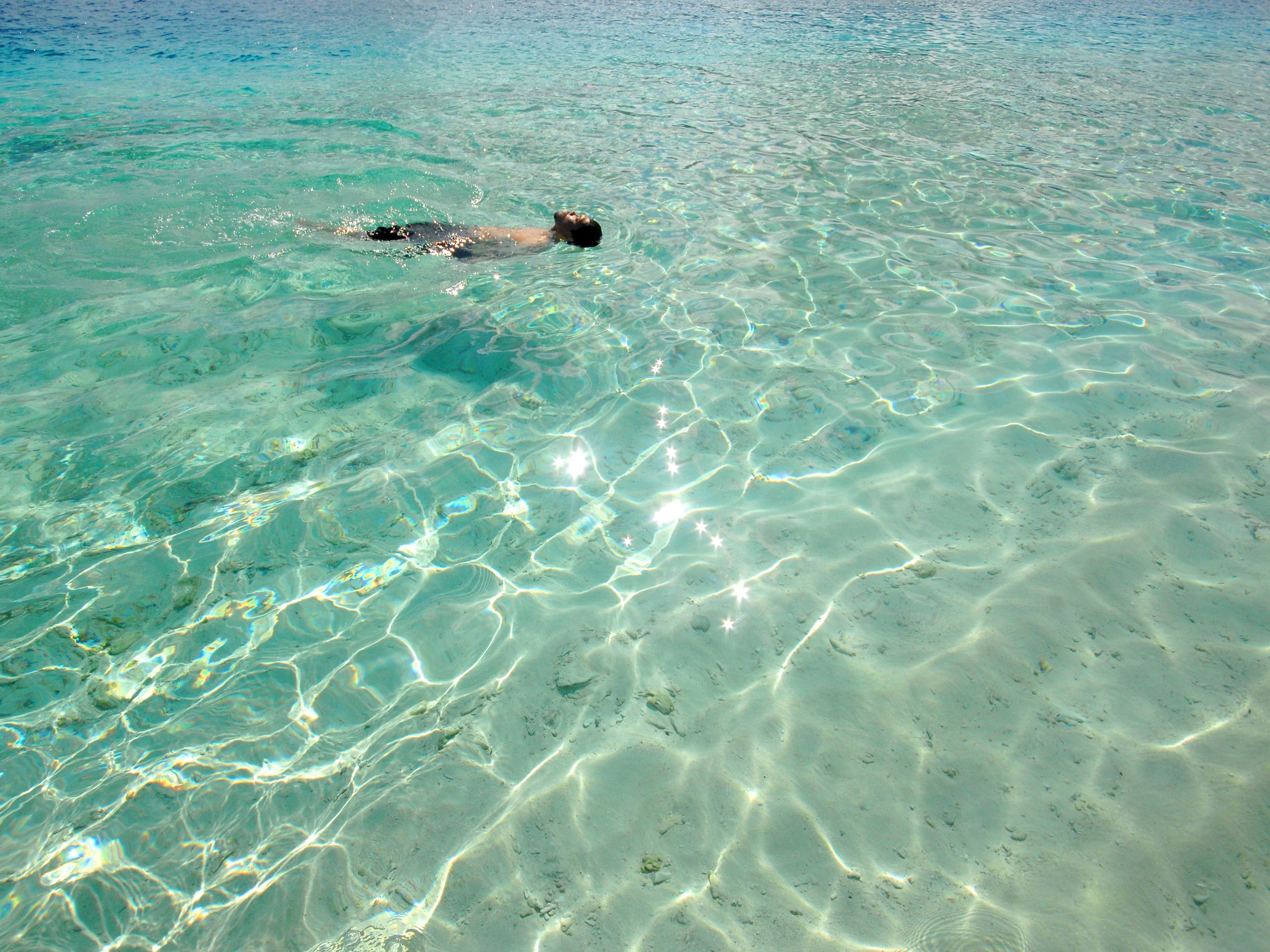 Seorang pria berenang di pesisir pantai Pulau Sara, Kabupaten Talaud, Sulawesi Utara, Selasa (26/10/2021).