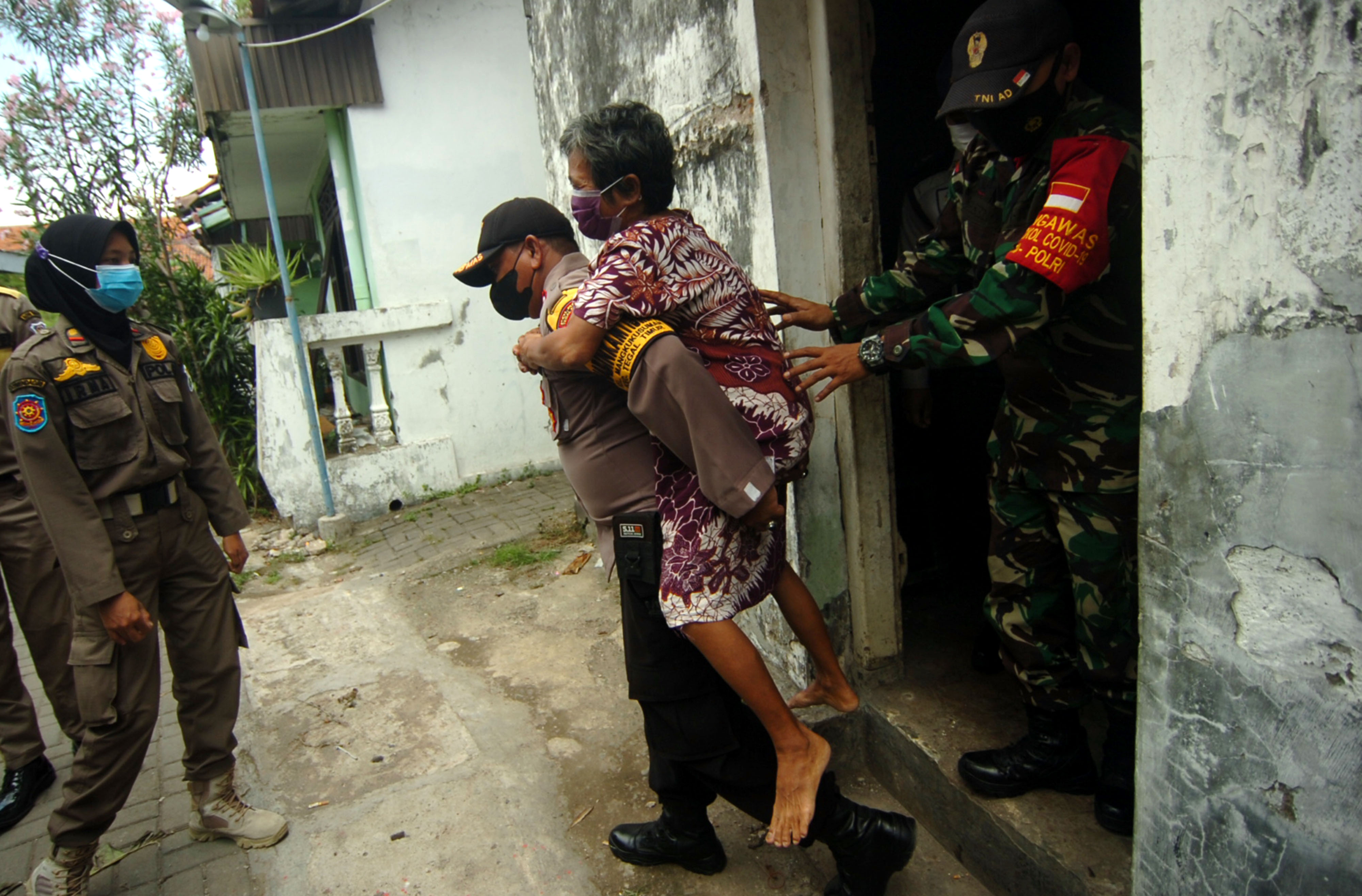 Personel gabungan membantu warga lansia untuk mendapatkan vaksin covid-19 di Kelurahan Mangkukusuman, Tegal, Jawa Tengah, Kamis (18/11/2021)