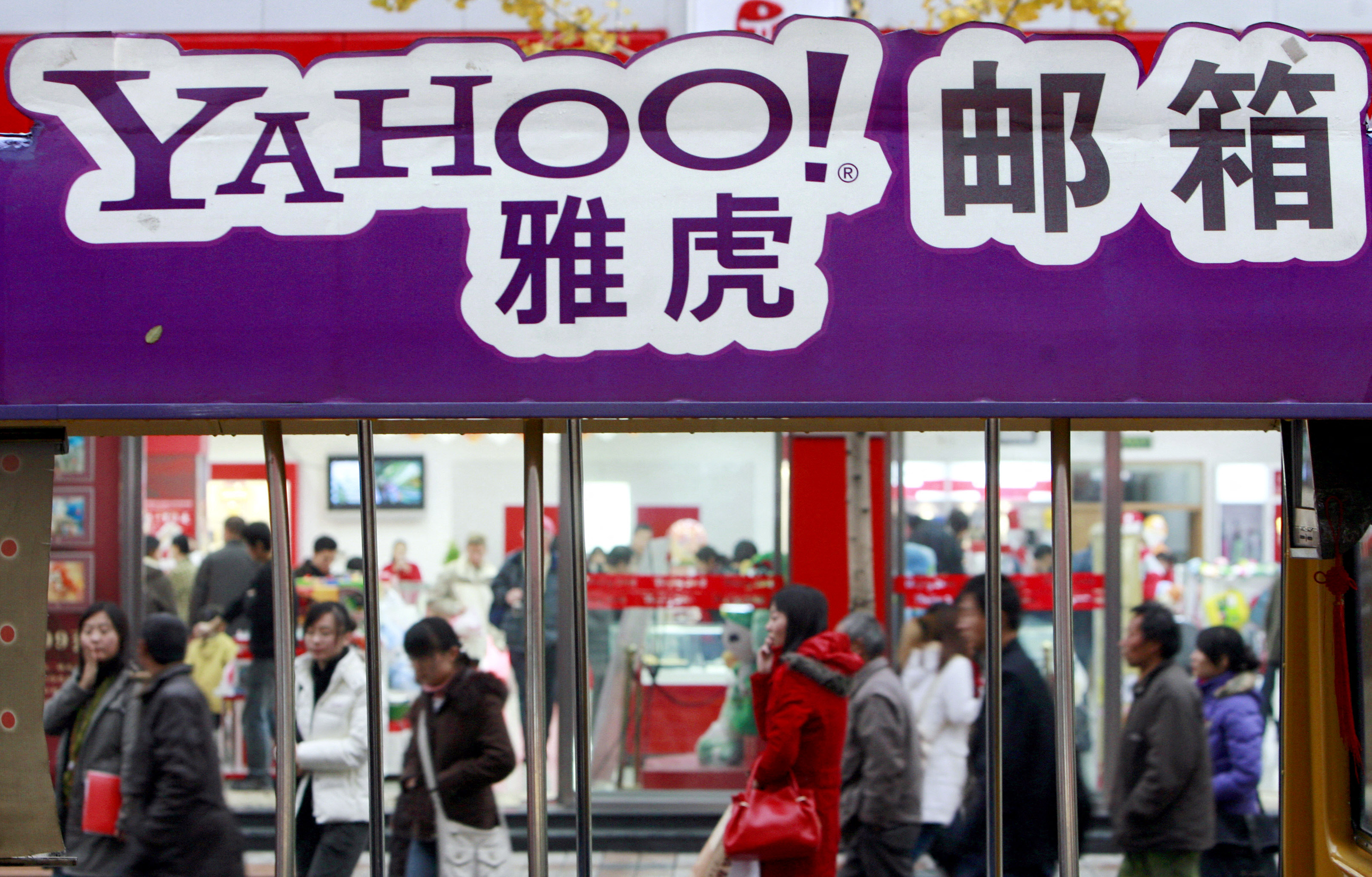 Sejumlah warga melintas di dekat billboard Yahoo di Beijing, Tiongkok.