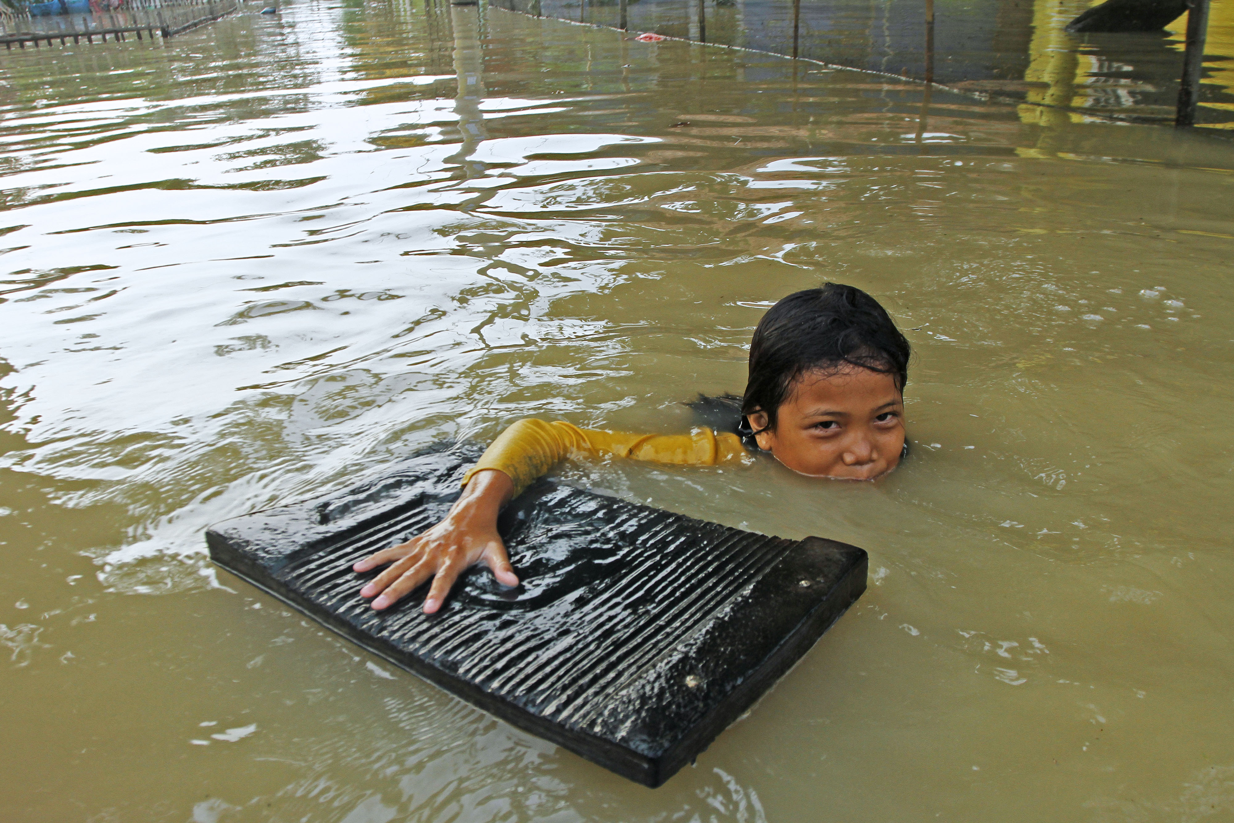 eorang anak bermain air saat banjir di Desa Karangligar, Karawang, Jawa Barat, Jumat (5/11/2021).