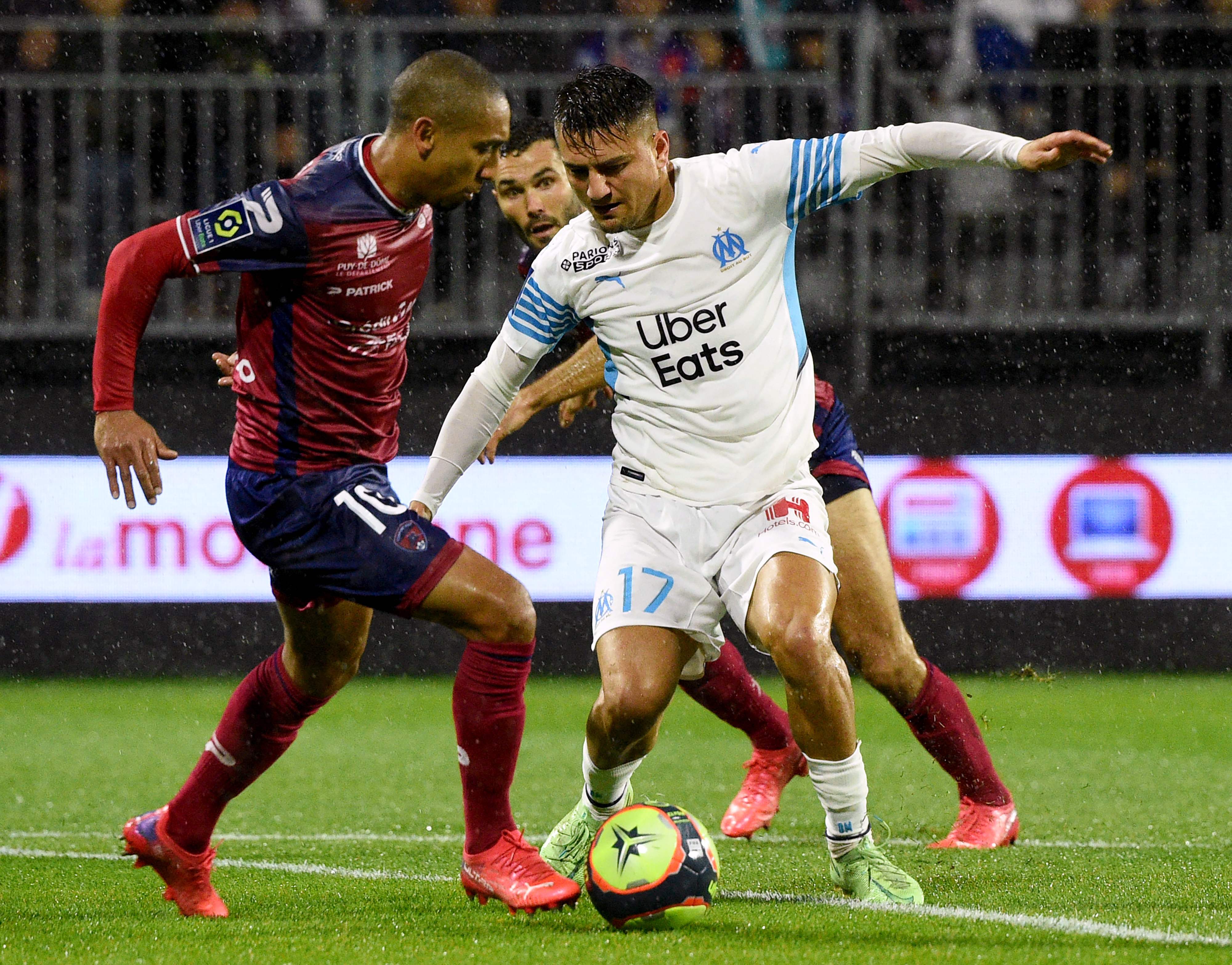 Aksi penyerang Marseille Cengiz Under (kanan) dalam laga Ligue 1 melawan Clairmont.