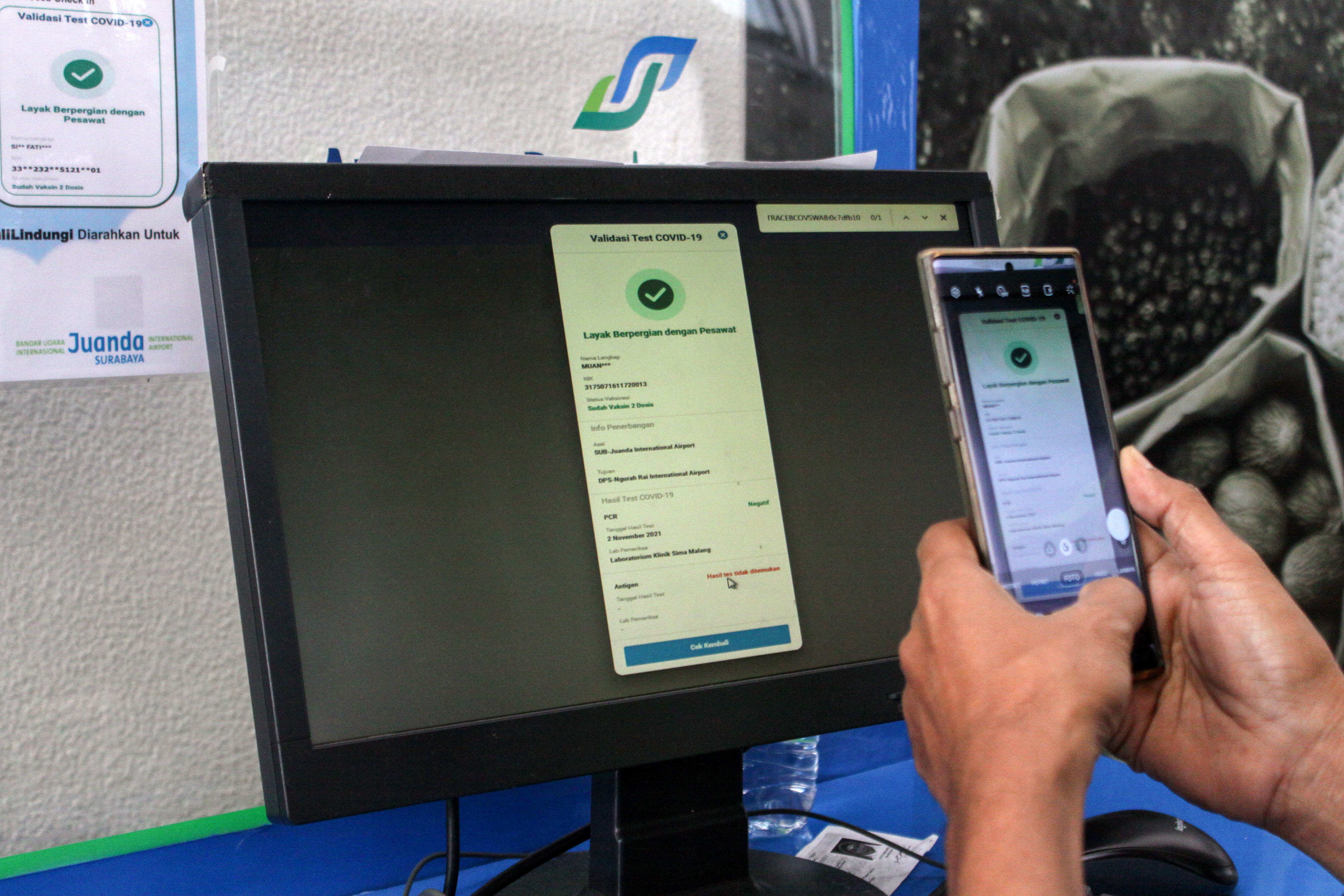 Penumpang di Bandara Internasional Juanda, Surabaya mendokumentasikan dokumen kesehatan untu syarat perjalanan