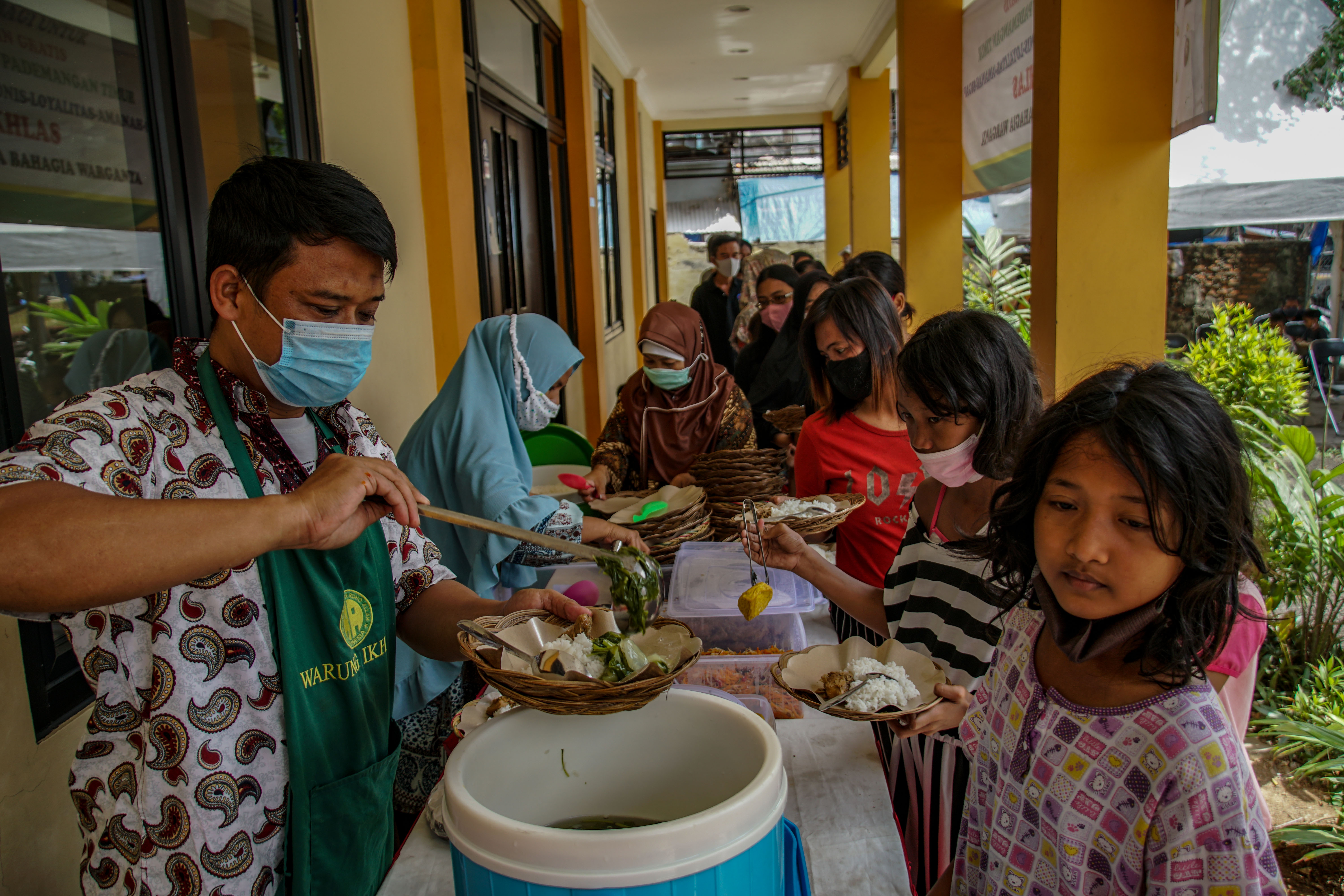 Sejumlah warga antre makanan gratis di Warung Ikhlas di kawasan Pademangan Timur, Jakarta Utara, Senin (8/11/2021). 