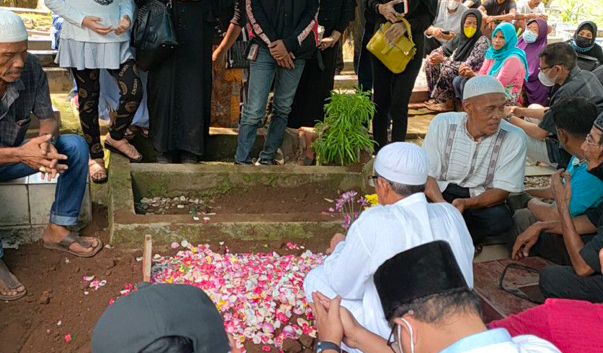 Anak-anak Max Sopacua tertunduk dan menangis saat menabur bunga di makam ayahandanya di Pemakaman keluarga di Gang Sadar, Ciomas Rahayu.