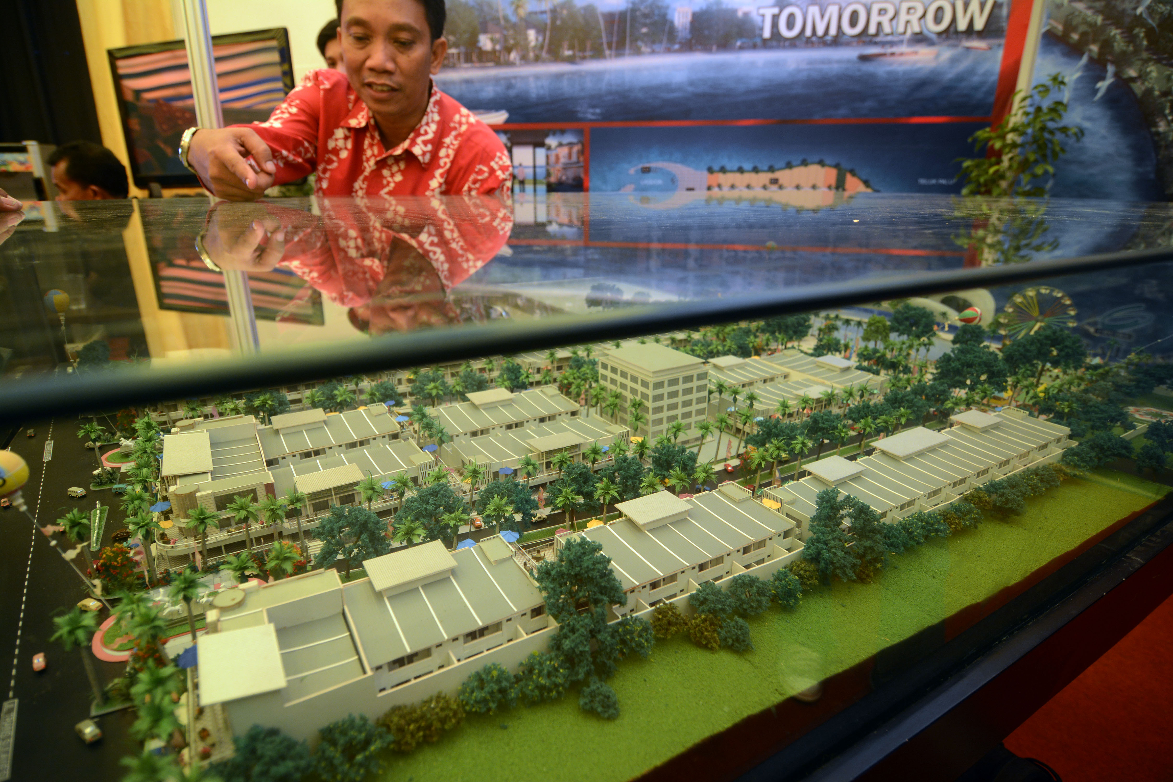 Pengunjung sedang mengamati maket pembangunan kawasan rumah mewah