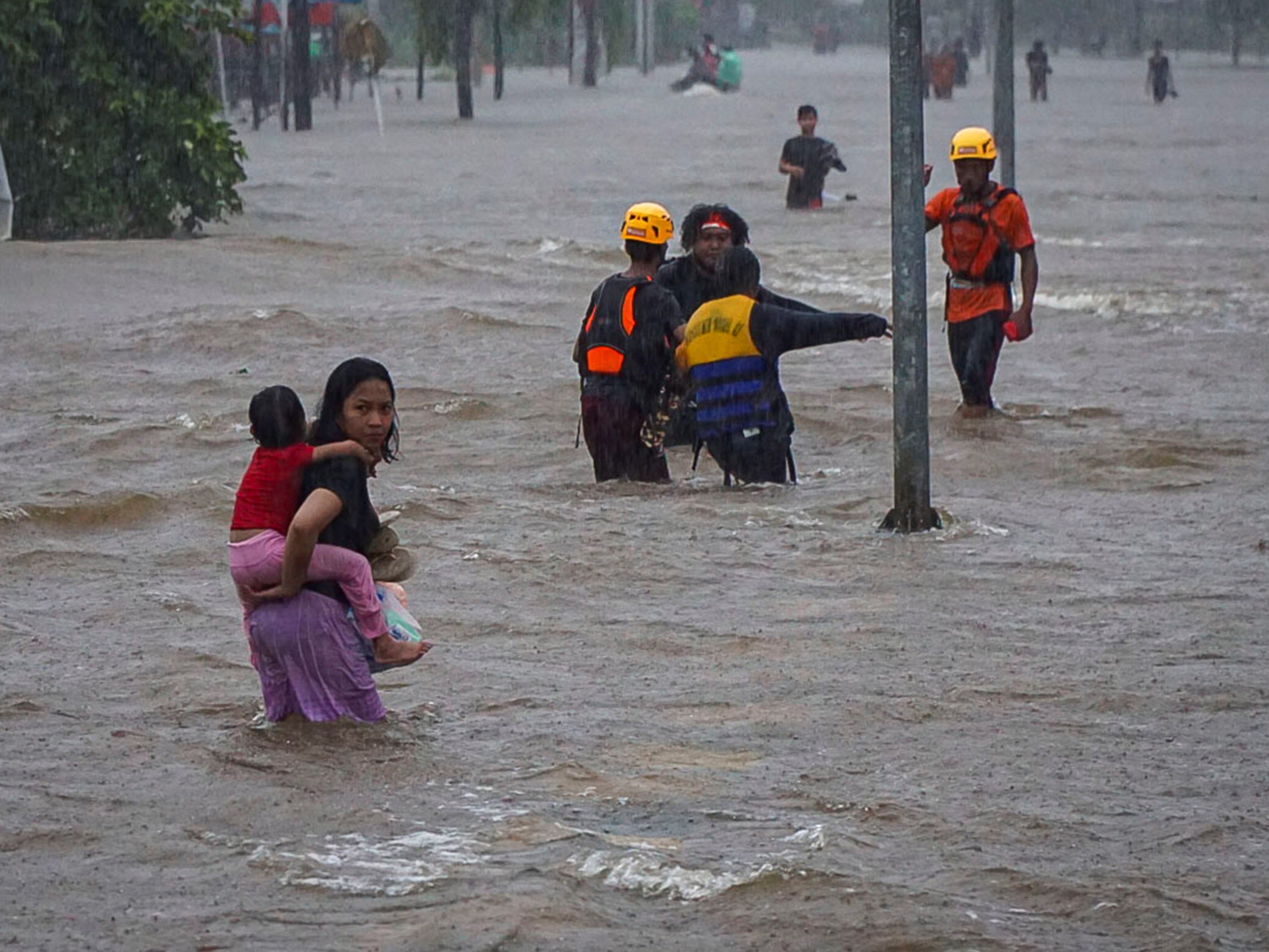 Sejumlah warga melintasi Jalan Lintas Melawi yang terdampak banjir di Ladang, Kabupaten Sintang, Kalimantan Barat, Jumat (12/11/2021).