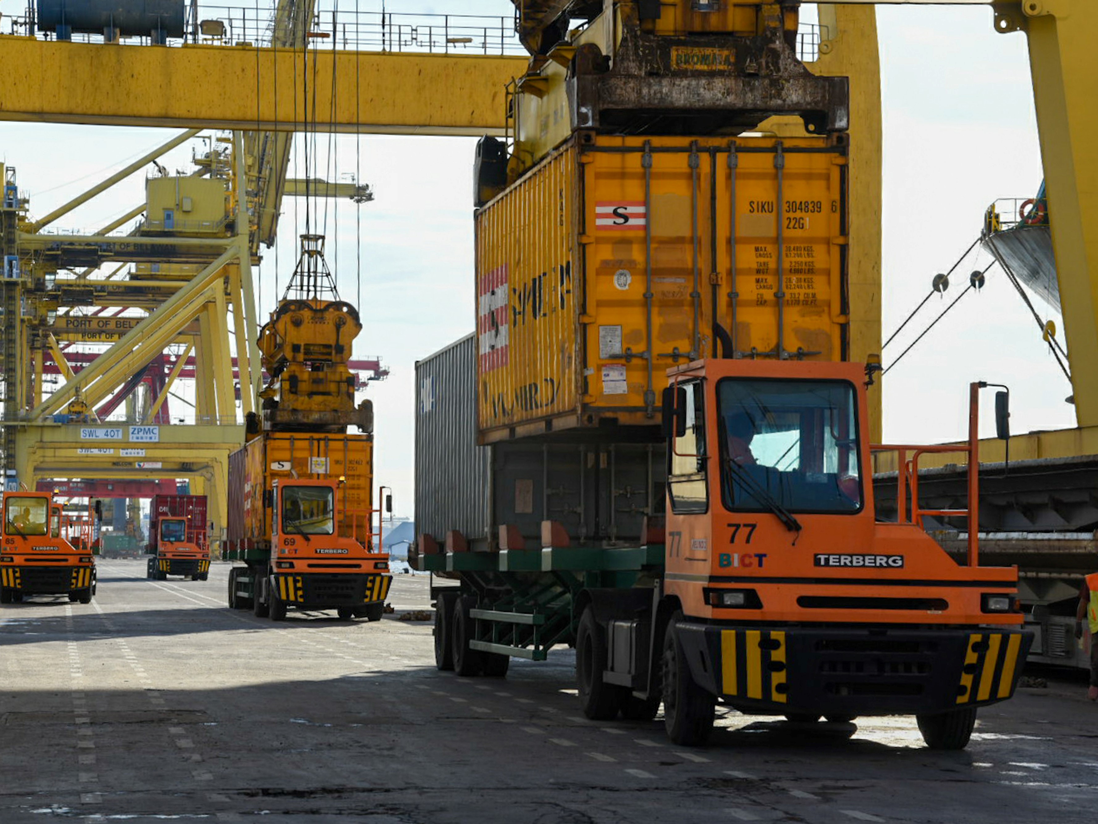 Petugas dibantu alat berat memindahkan peti kemas di Terminal Peti Kemas International Belawan, Kota Medan, Sumut.