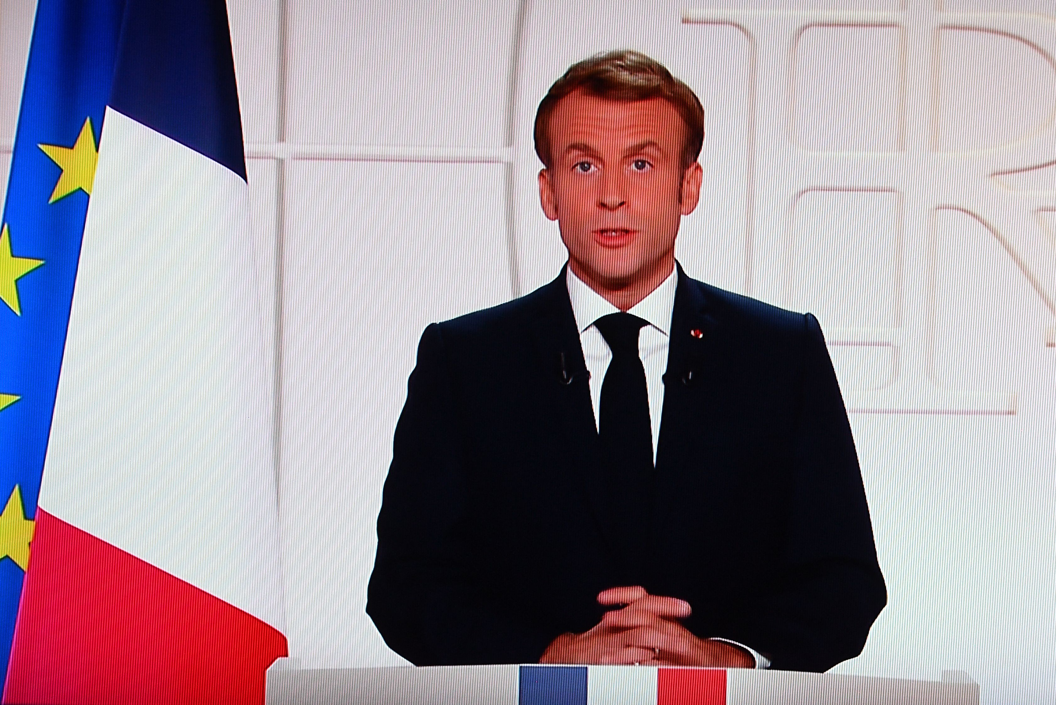 Tampak dalam monitor televisi Presiden Prancis Emmanuel Macron berpidato mengenai penundaan pelonggaran anti-Covid-19. 