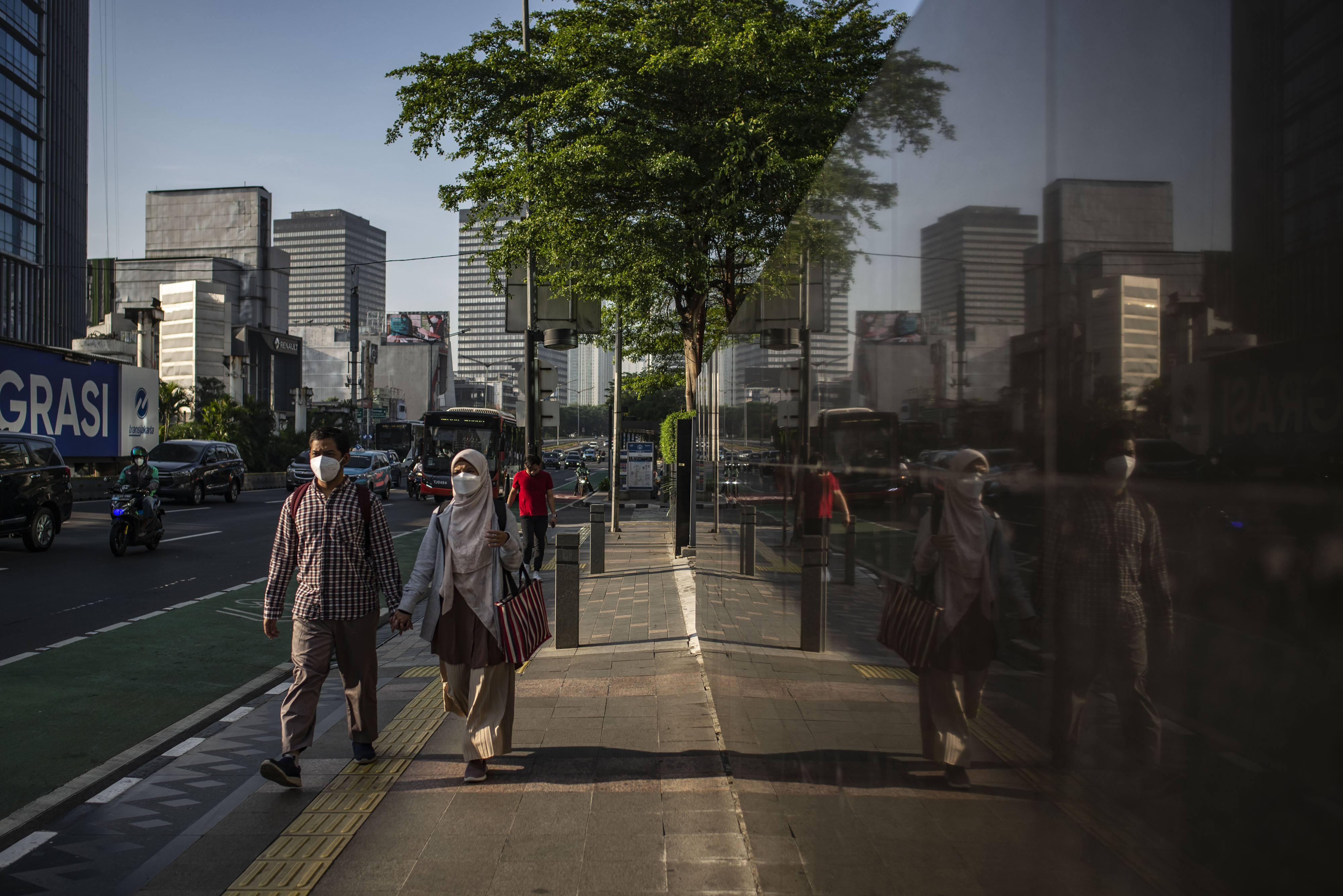 Sejumlah warga berjalan di Jakarta, Jumat (24/9). Menkominfo Johnny G. Plate meminta seluruh masyarakat tetap waspada gelombang ketiga covid