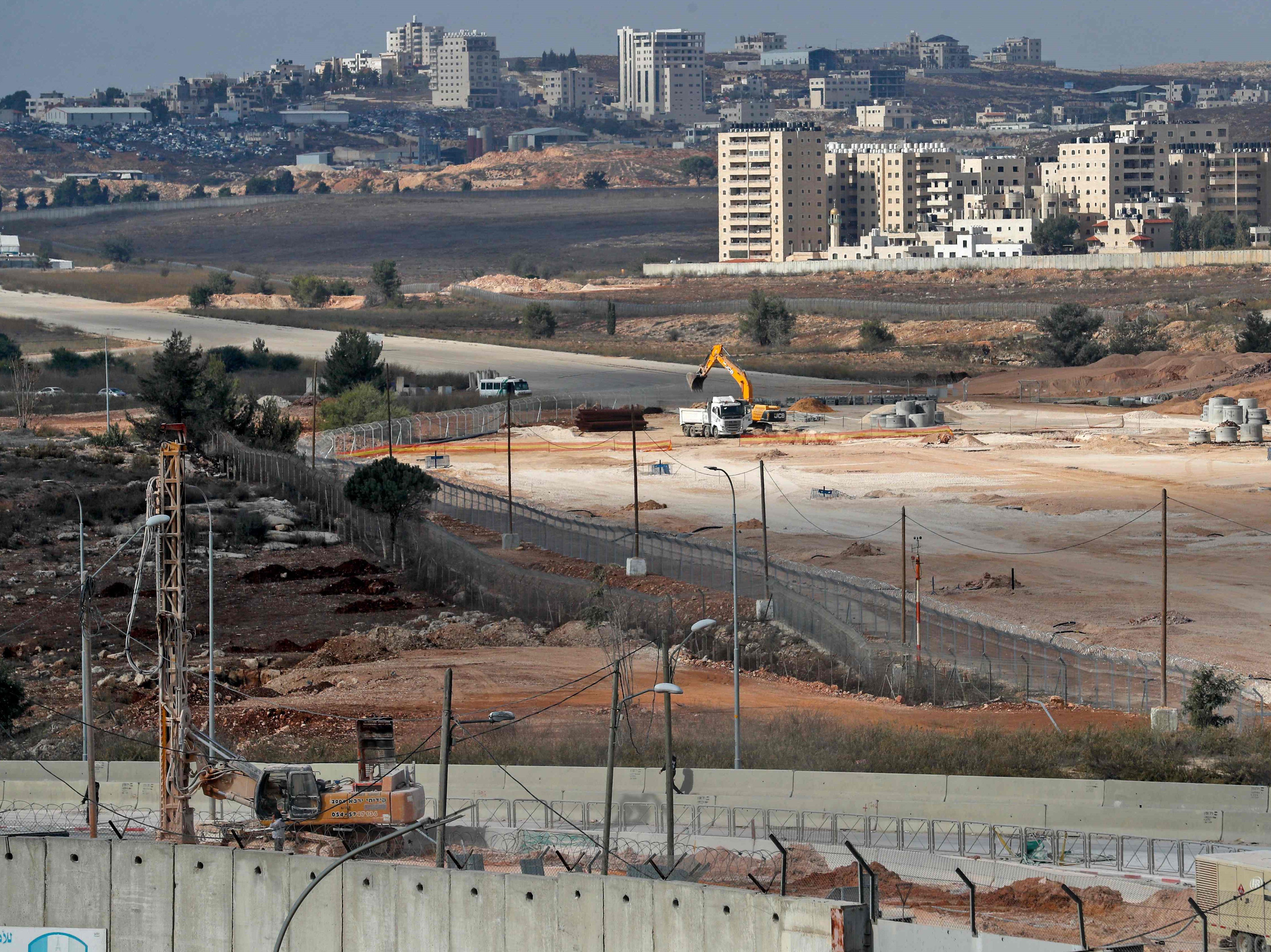 Pandangan umum menunjukkan bagian dari tembok pemisah kontroversial Israel (bawah) dan landasan bekas bandara Atarot.