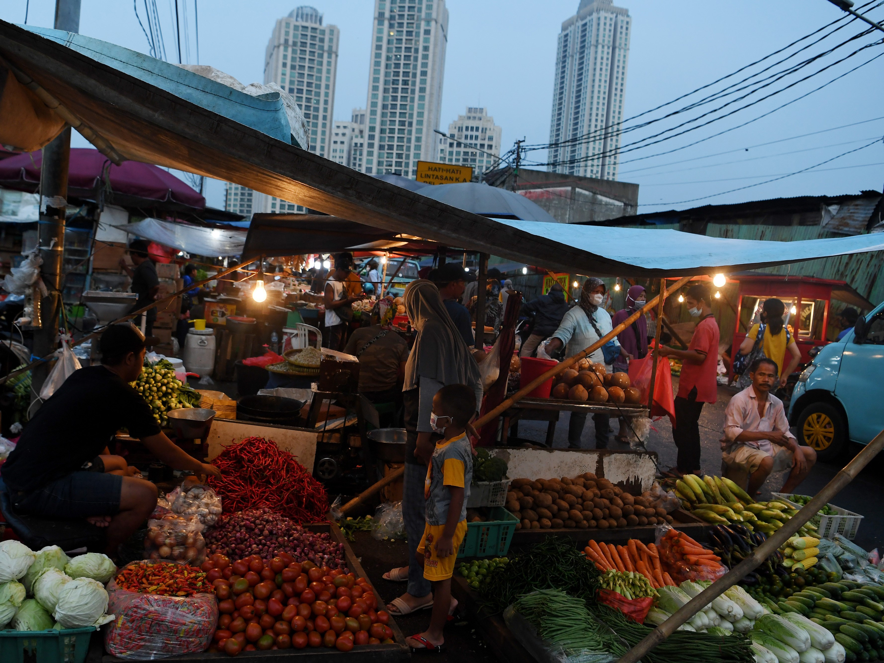 Pedagang sayur melayani pembeli di kawasan Pasar Kebayoran Lama, Jakarta, Senin (25/10/2021).